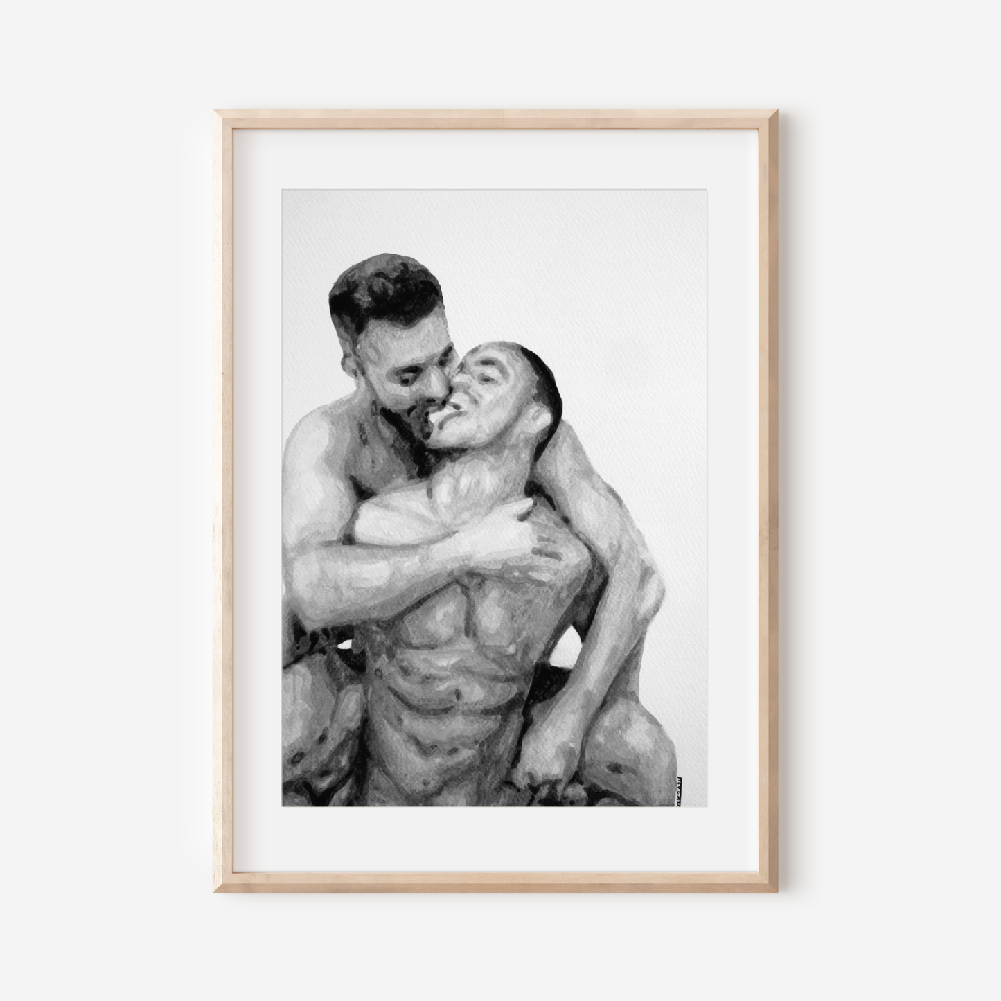 Framed black and white photograph of two people embracing on a white wall.