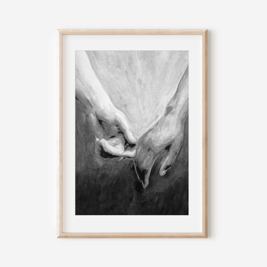 Framed black and white artwork of two hands holding each other on a white wall.
