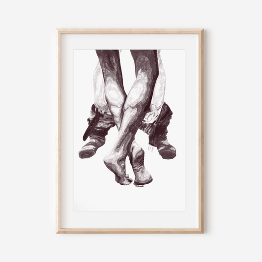 Framed artwork of feet in boots on a white wall