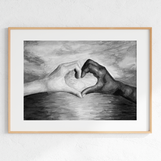 Framed black and white artwork of two hands forming a heart shape over water.
