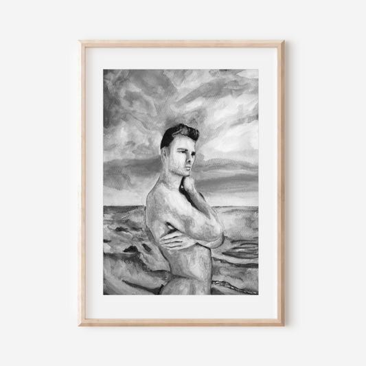 Framed black and white artwork of a nude figure on a beach.