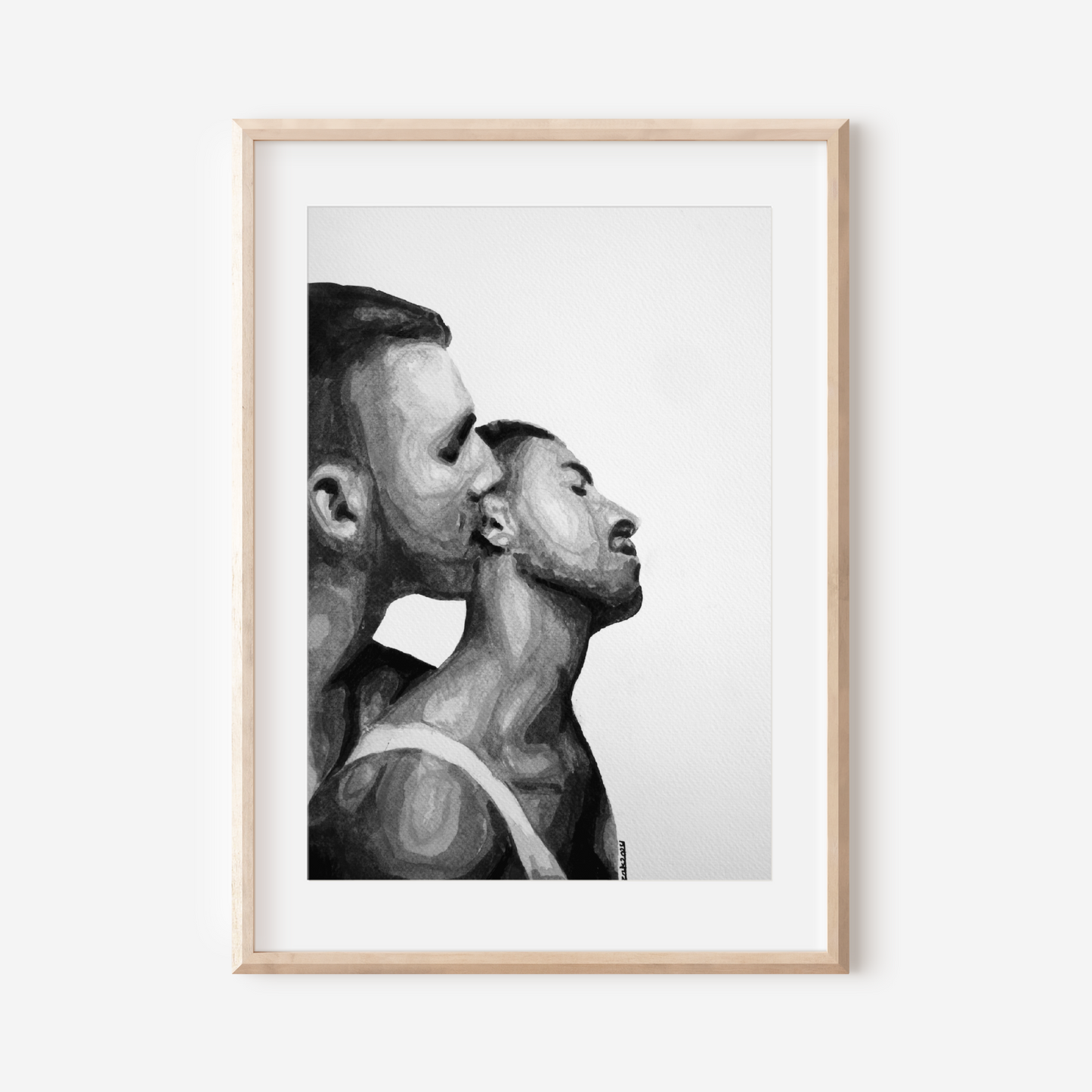 Framed black and white artwork of two men in a close embrace on a white wall.
