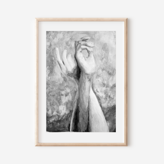 Framed black and white artwork of hands on a white wall