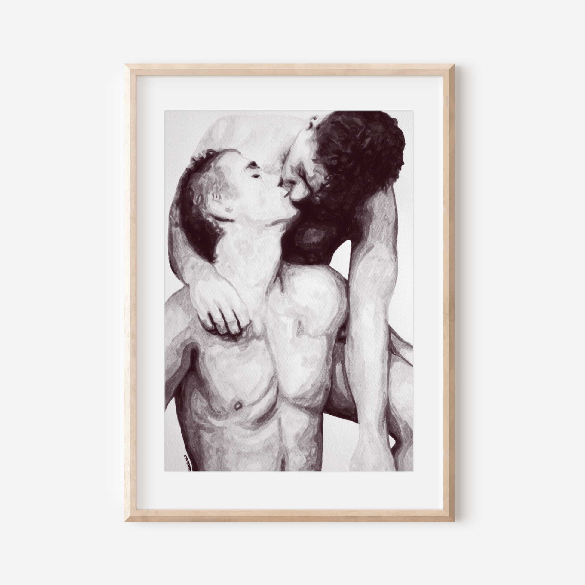 Framed black and white artwork of two nude figures embracing on a white wall.