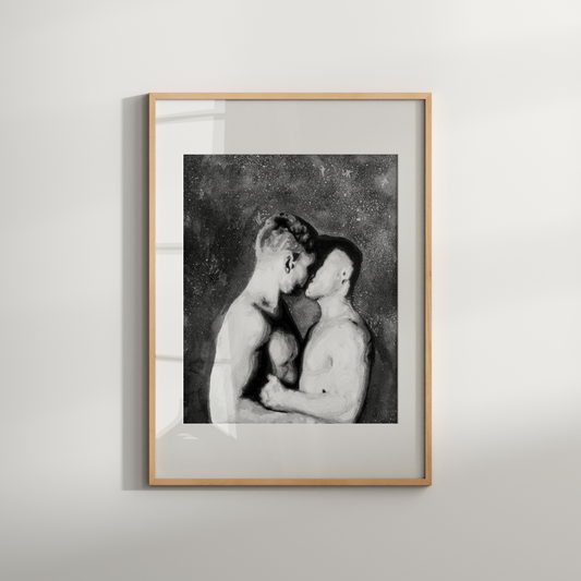 Framed black and white artwork of two nude figures on a light gray wall.