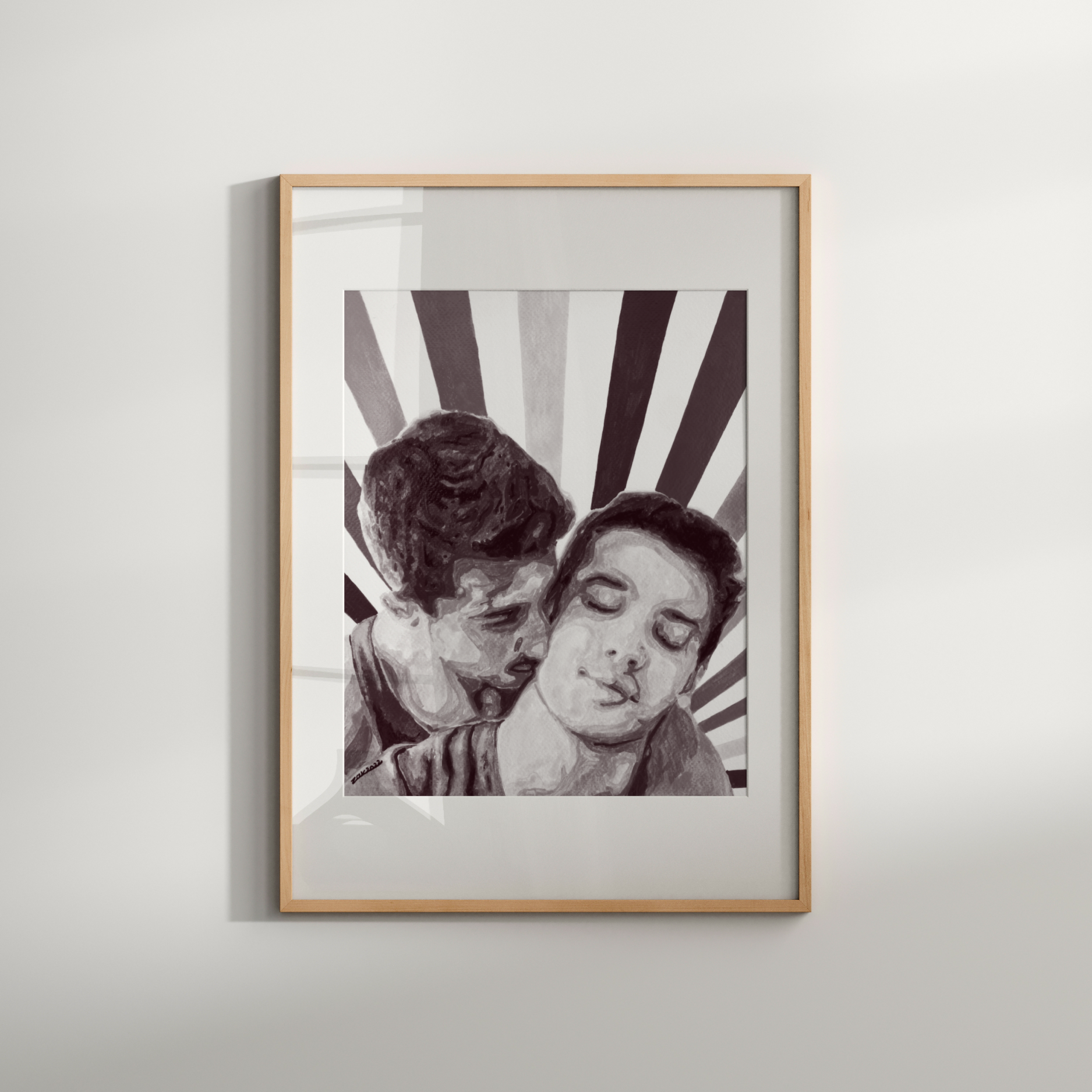 Framed black and white artwork of two people embracing on a light gray wall.