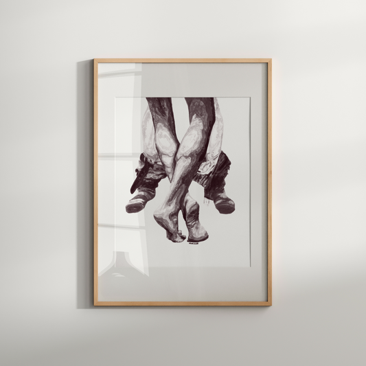 Framed black and white artwork of feet on a light gray wall