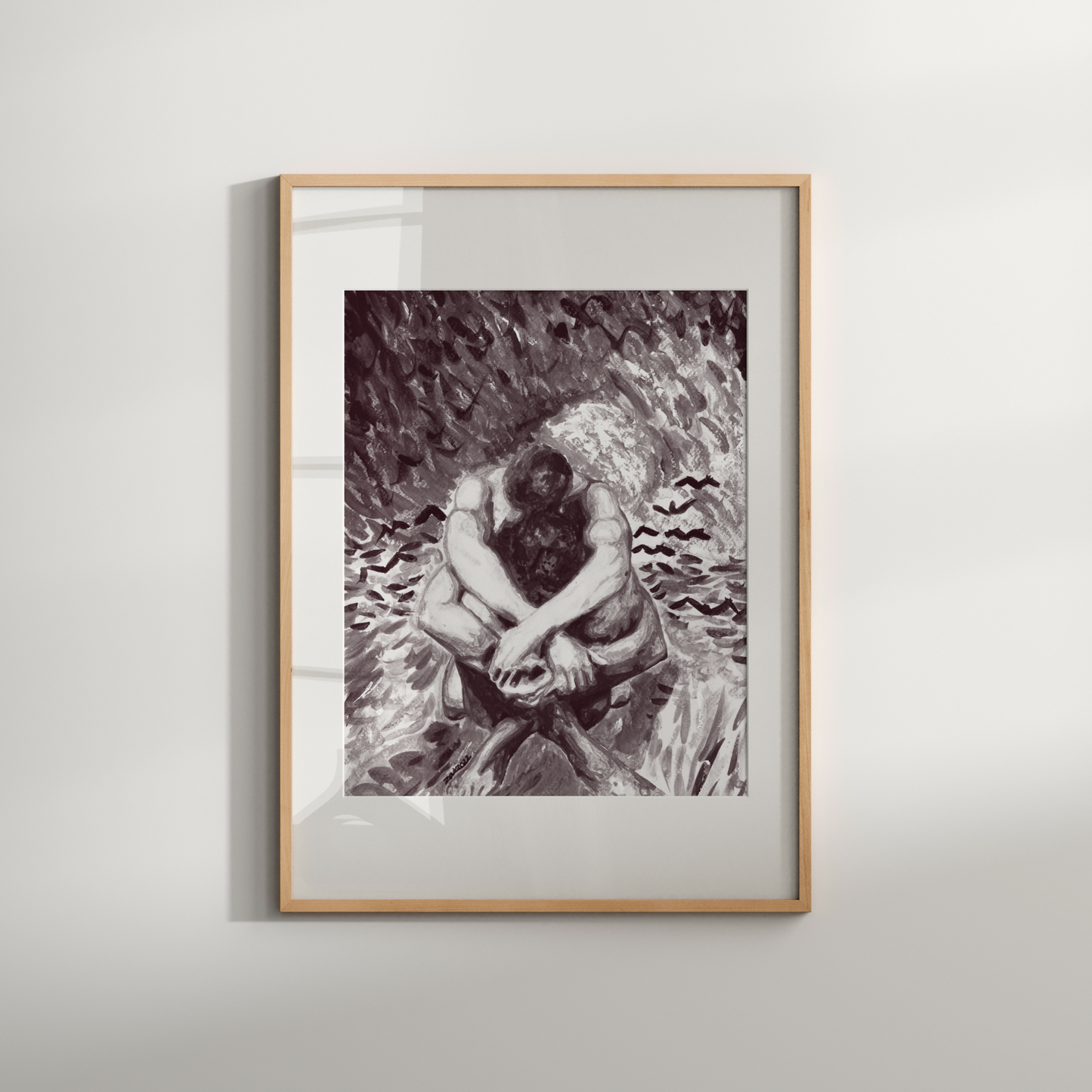 Framed black and white artwork of a person sitting on a rock against a plain wall.