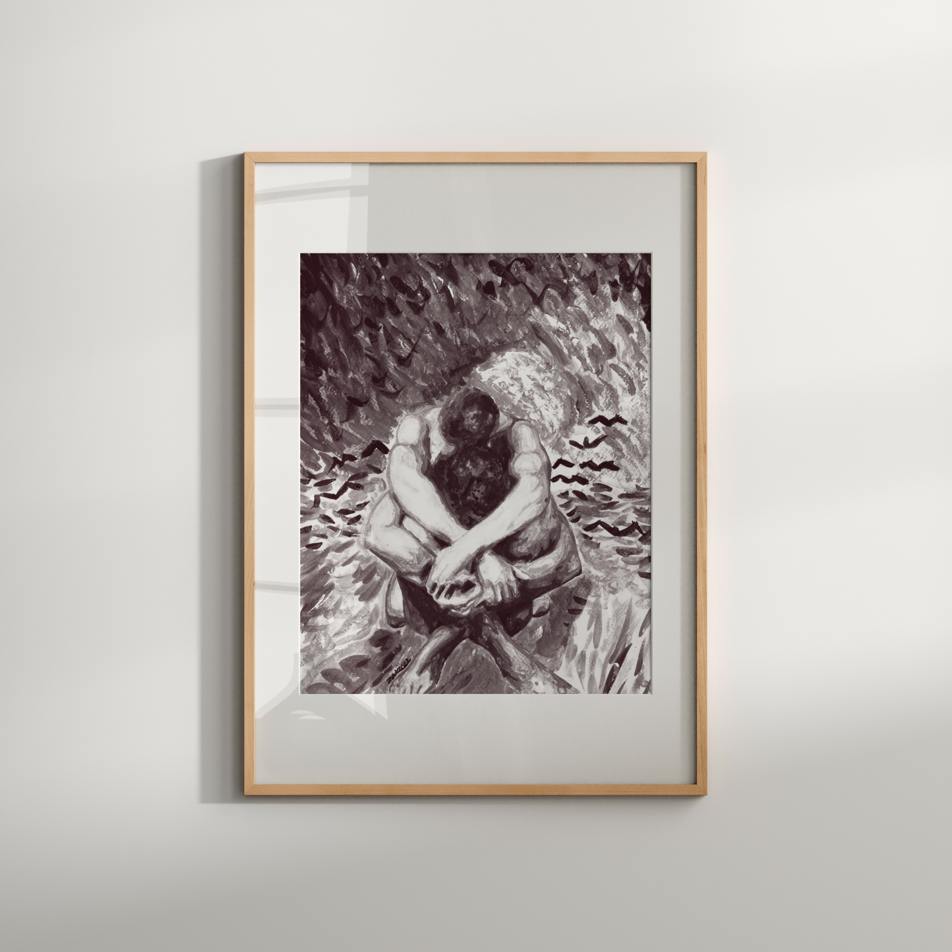 Framed black and white artwork of a person sitting on a rock against a plain wall.