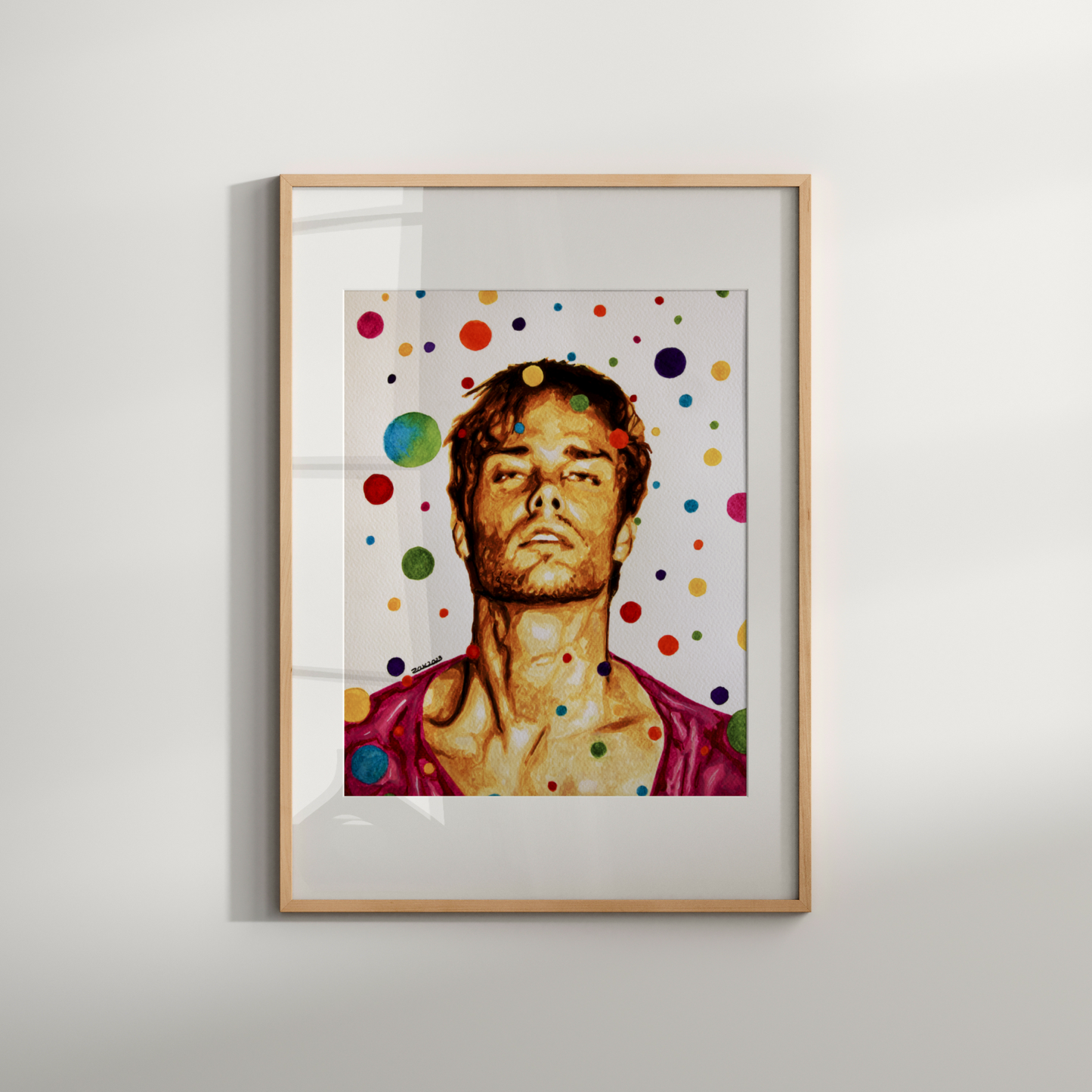Framed artwork of a person with colorful polka dots on a white wall