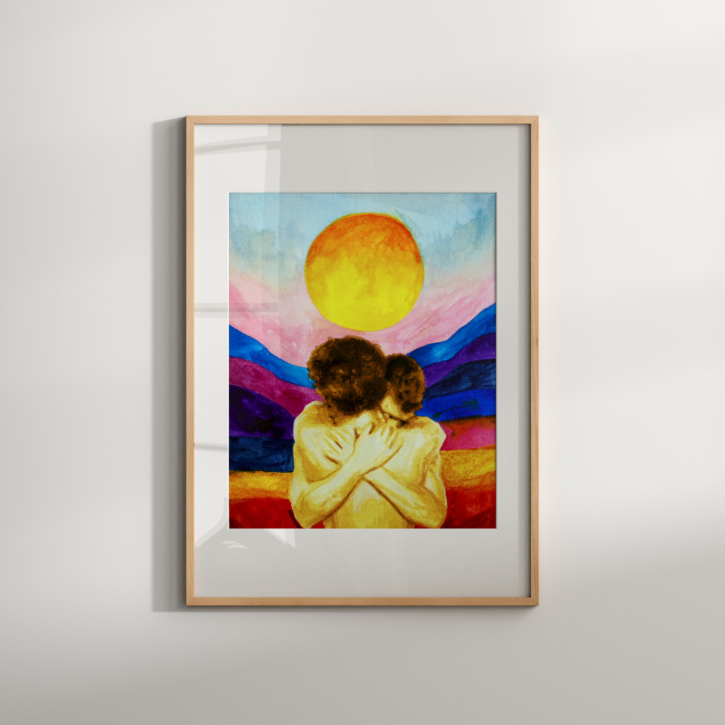 Framed artwork of two people embracing under a colorful sky with a large sun on a white wall.