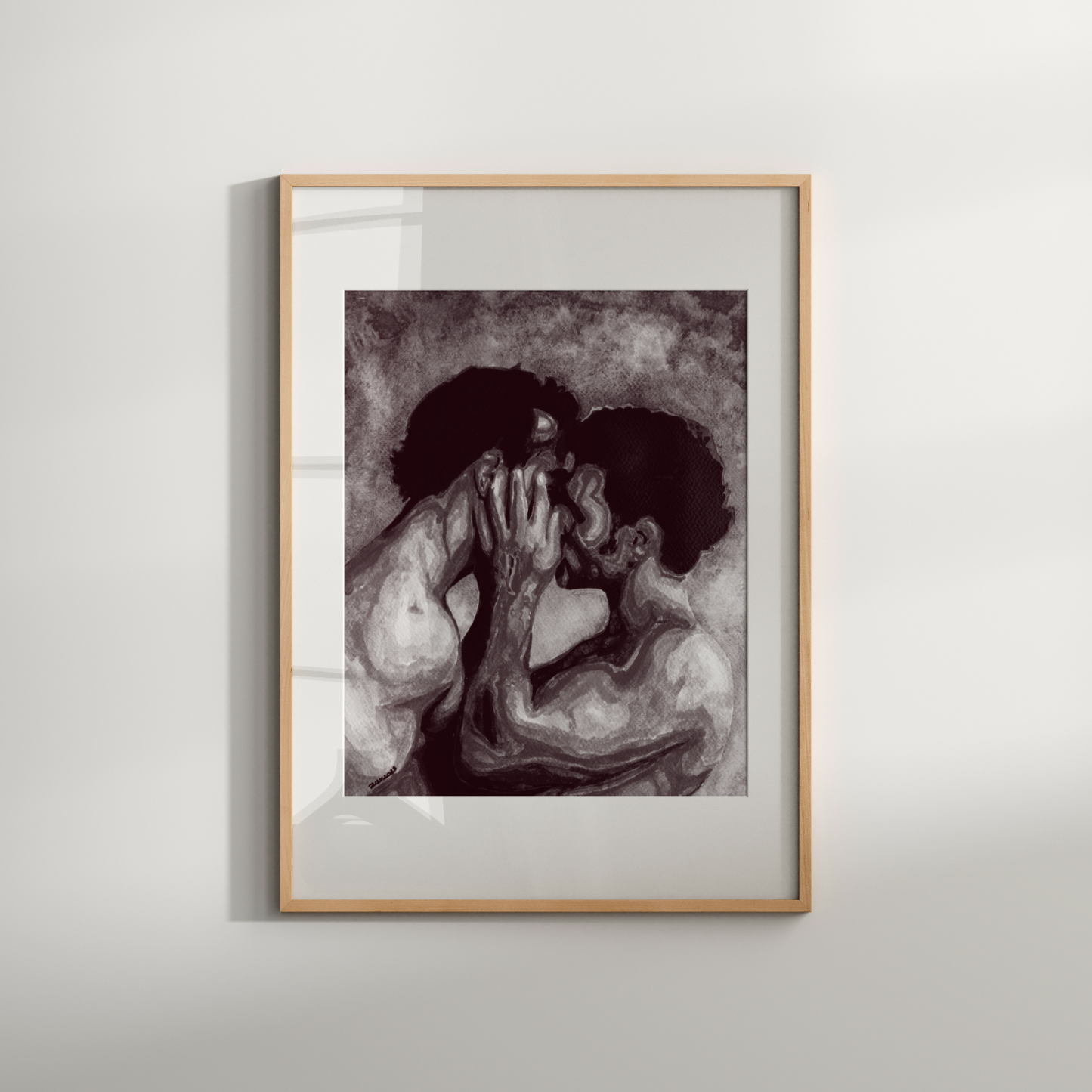 Framed artwork of two people embracing on a white wall