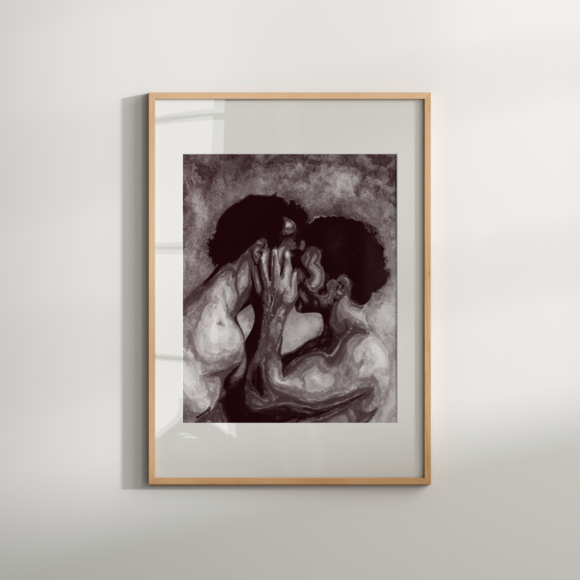 Framed artwork of two people embracing on a white wall