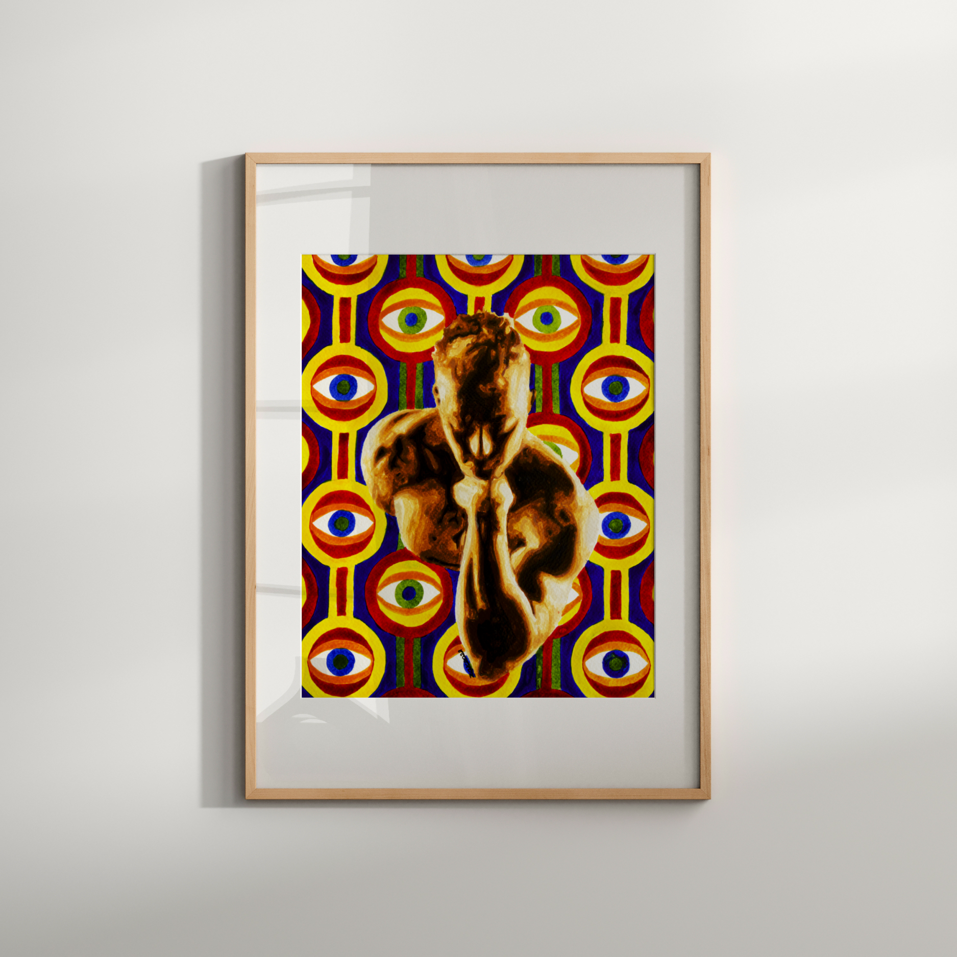 Framed artwork with a colorful abstract design and a cat's face on a white wall.