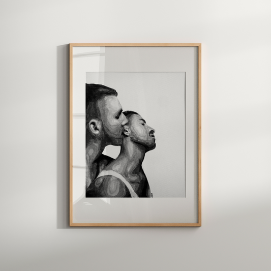 Framed black and white artwork of two men in a close embrace on a white wall.
