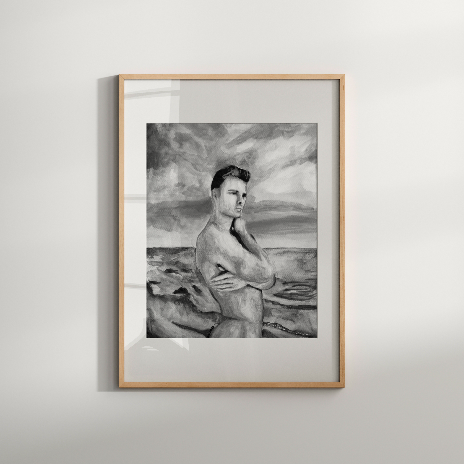 Framed black and white artwork of a person on a beach against a gray wall.