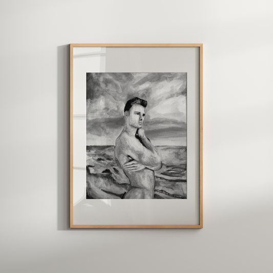 Framed black and white artwork of a person on a beach against a gray wall.
