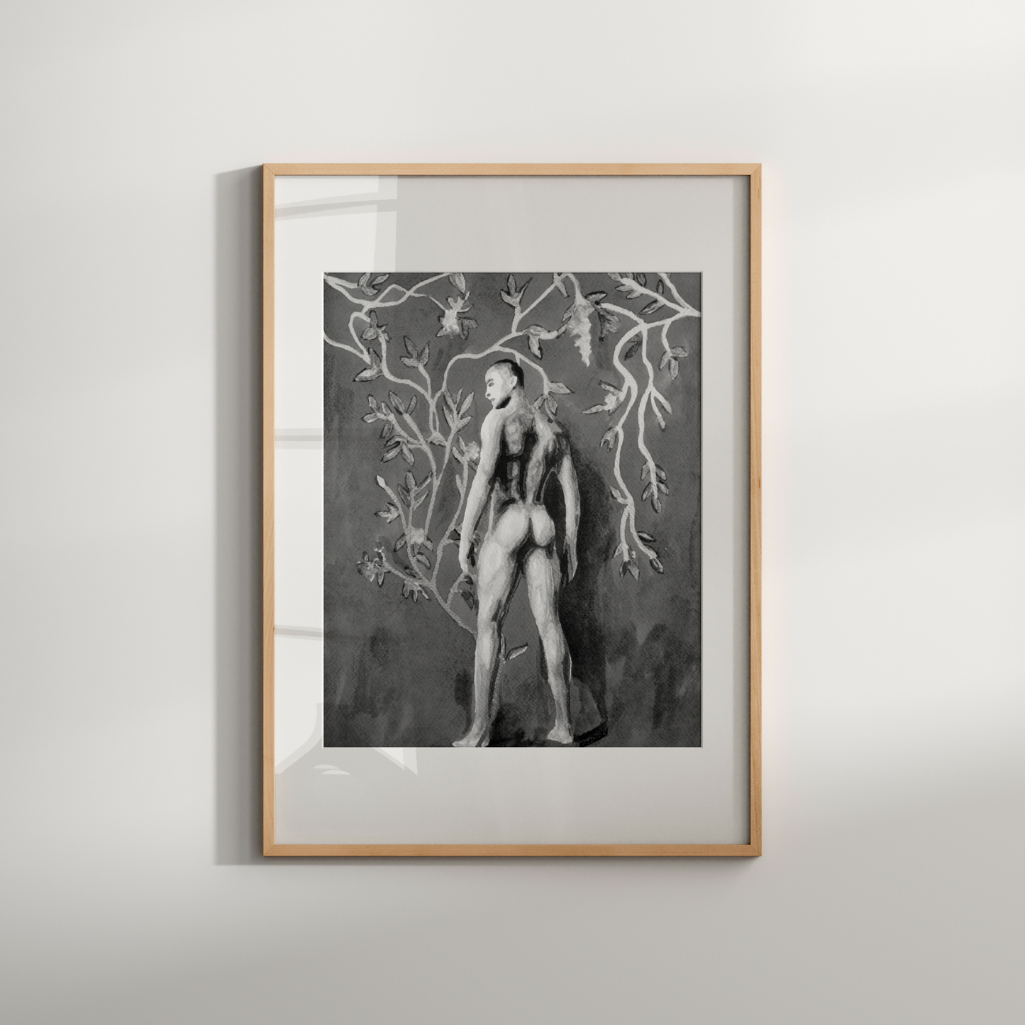 Framed artwork of a nude figure with tree branches on a white wall