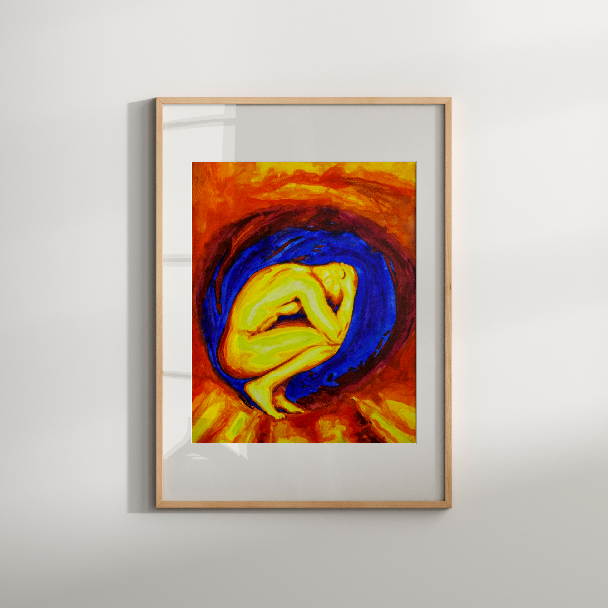 Framed abstract artwork with a central figure in blue and yellow on a white wall.