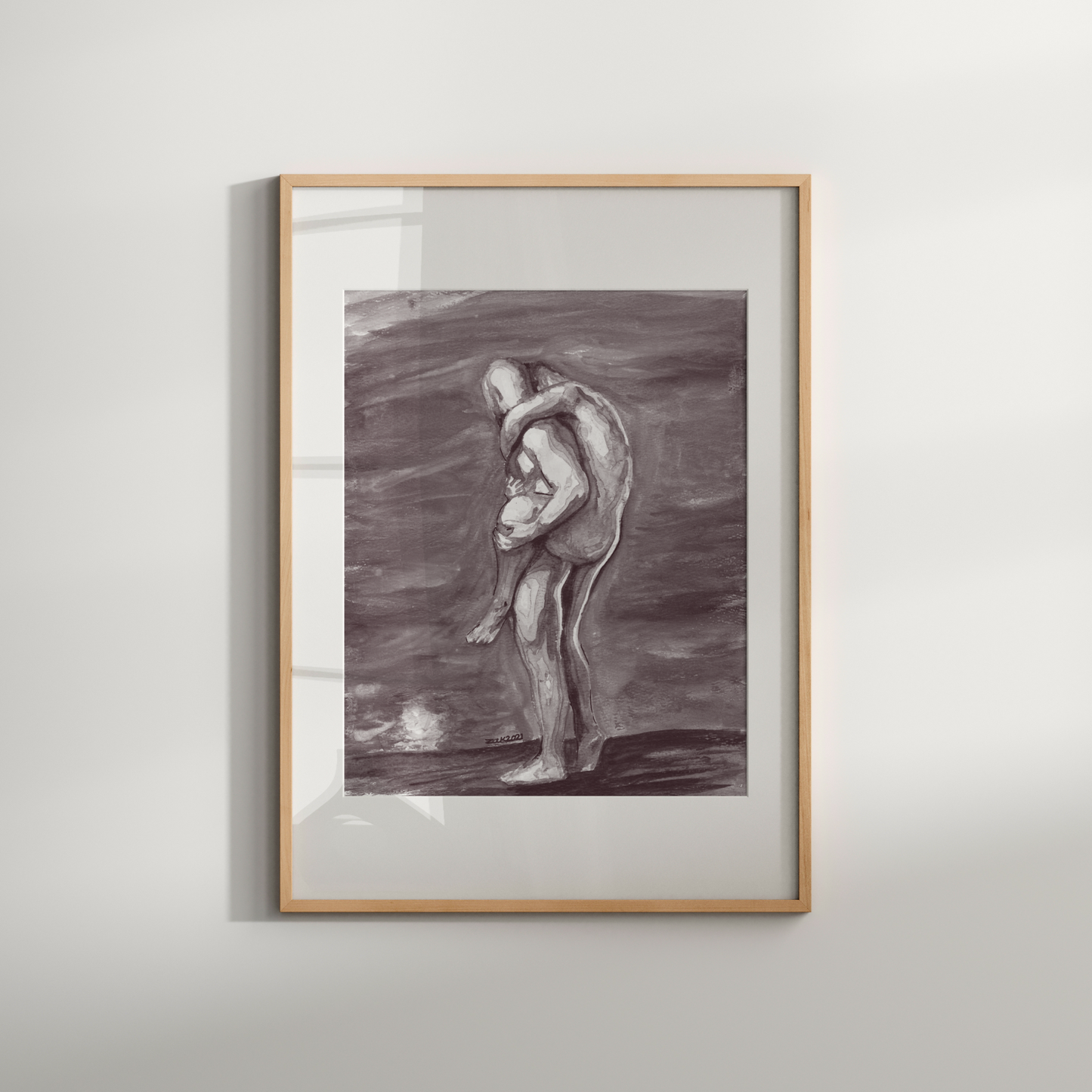 Framed artwork of a nude figure holding a child on a white wall