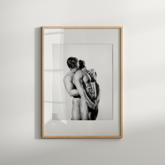 Framed black and white artwork of two people embracing on a light gray wall.