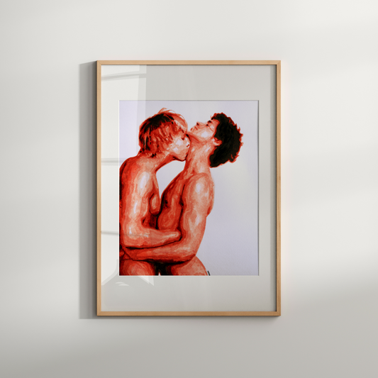 Framed artwork of two nude figures embracing on a white wall.