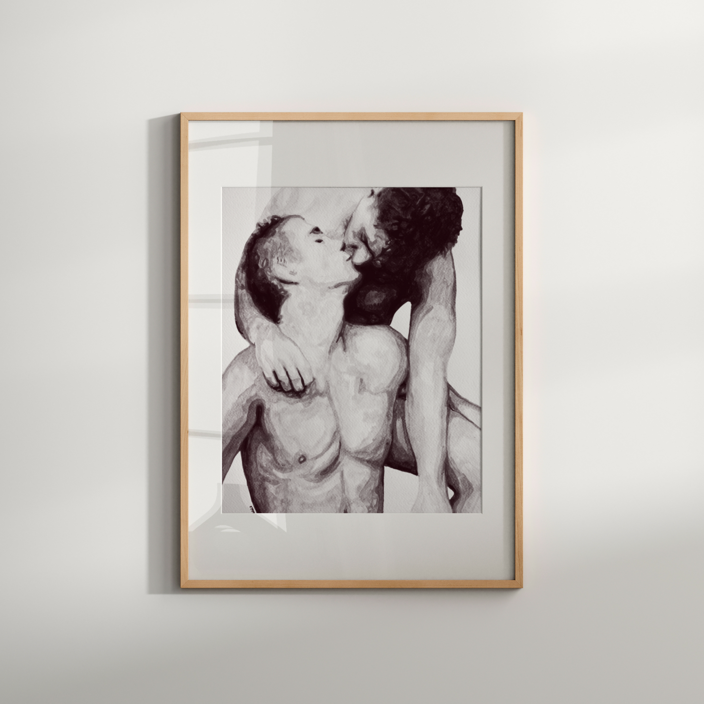 Framed black and white photograph of two people embracing on a light gray background