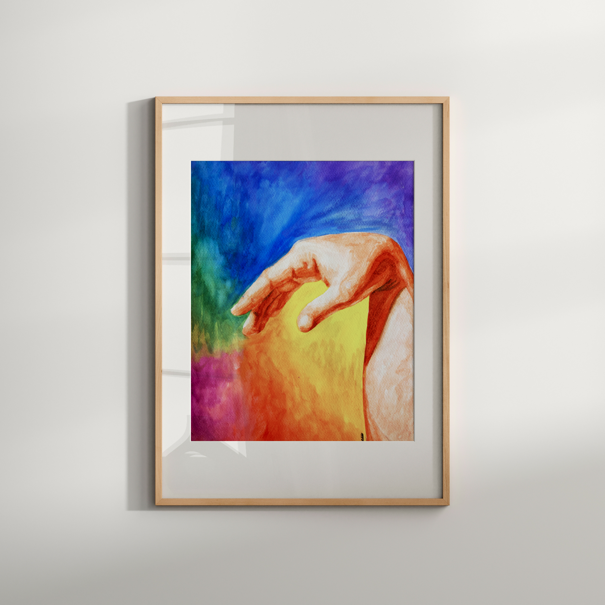 Framed artwork of a colorful hand holding an apple on a white wall