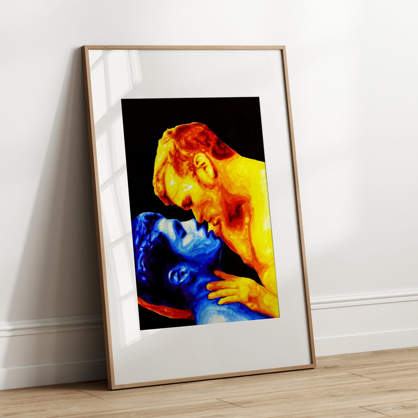 Framed artwork of a colorful depiction of a gay cople embracing on a white wall.
