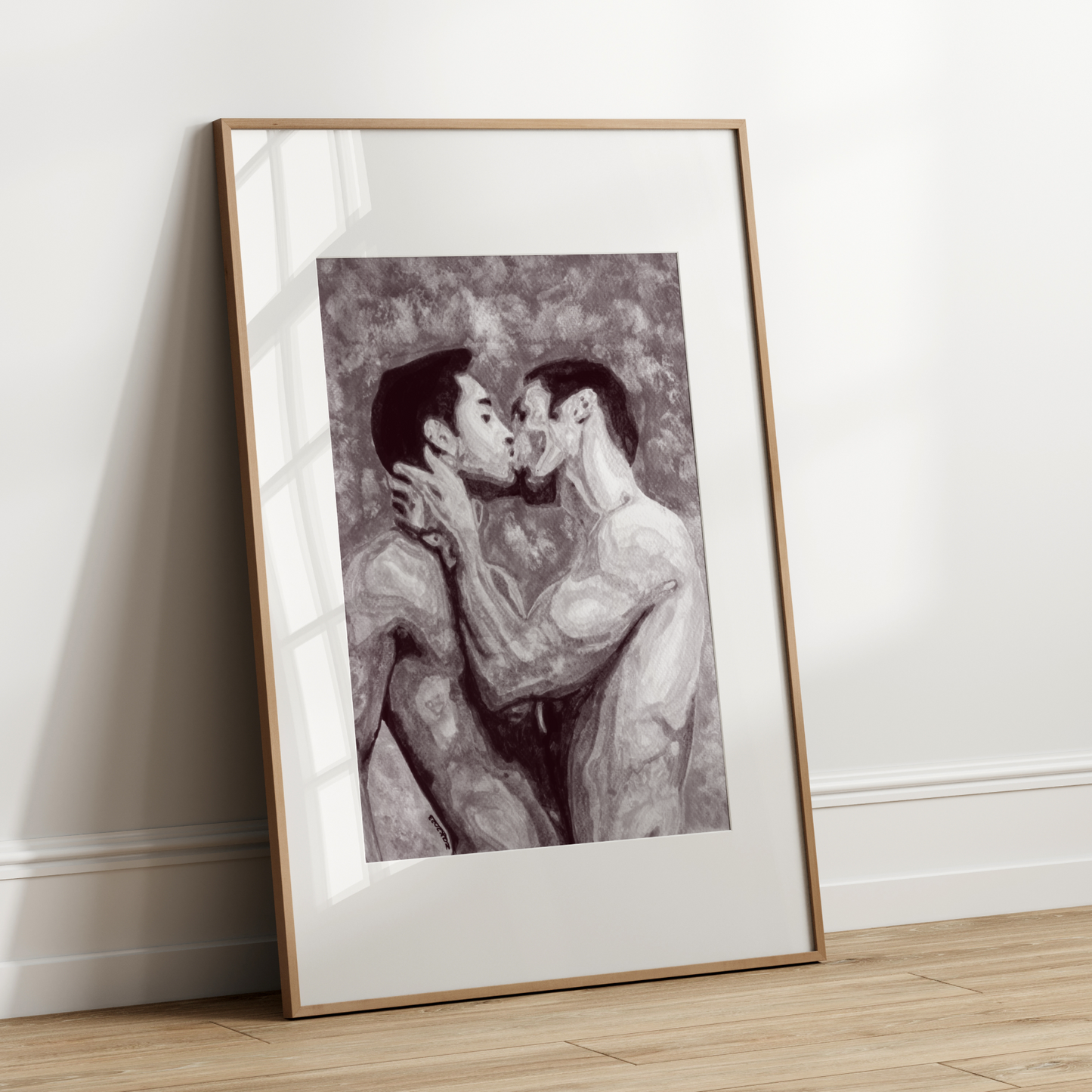 Framed artwork of two people embracing on a white wall.