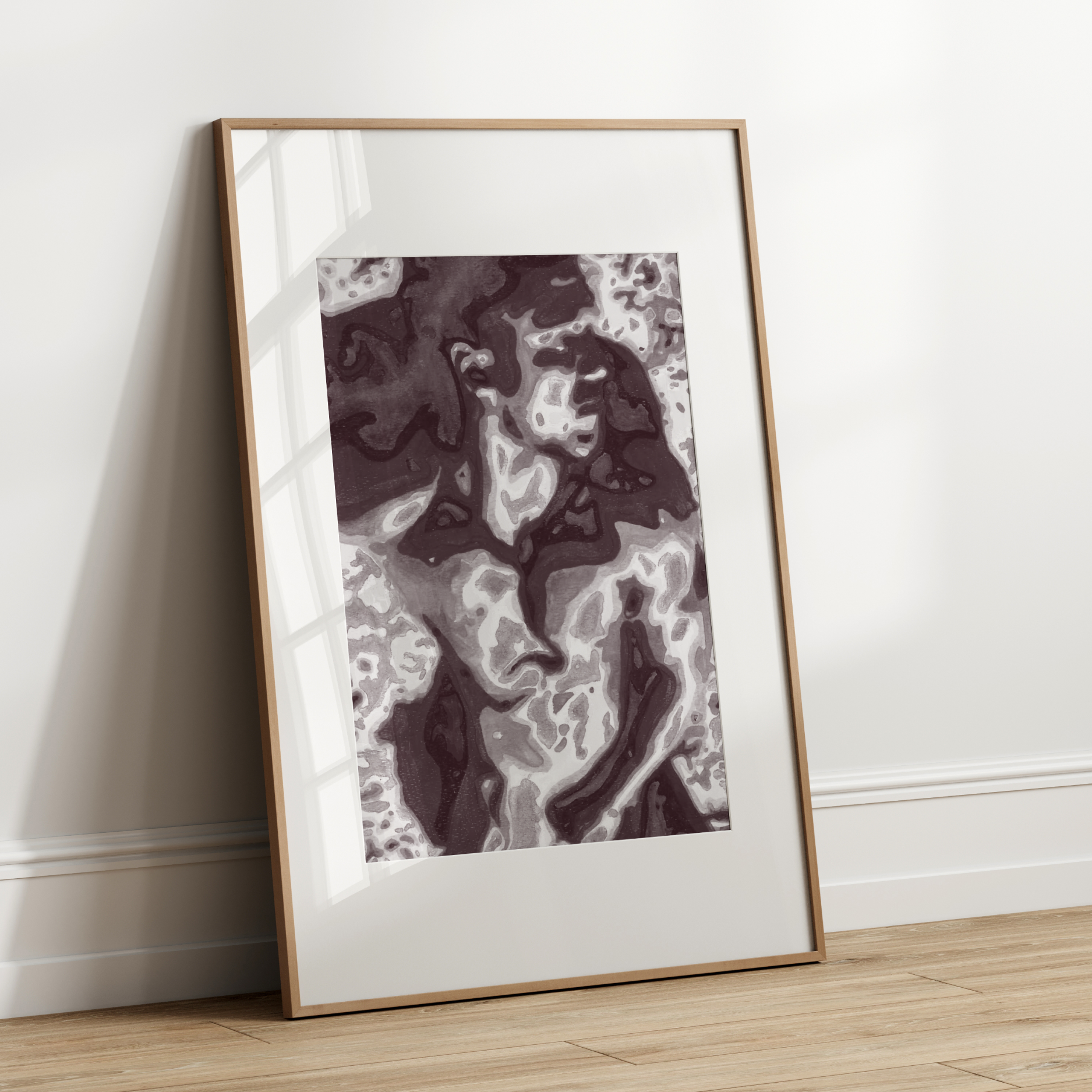 Framed abstract artwork leaning against a white wall.