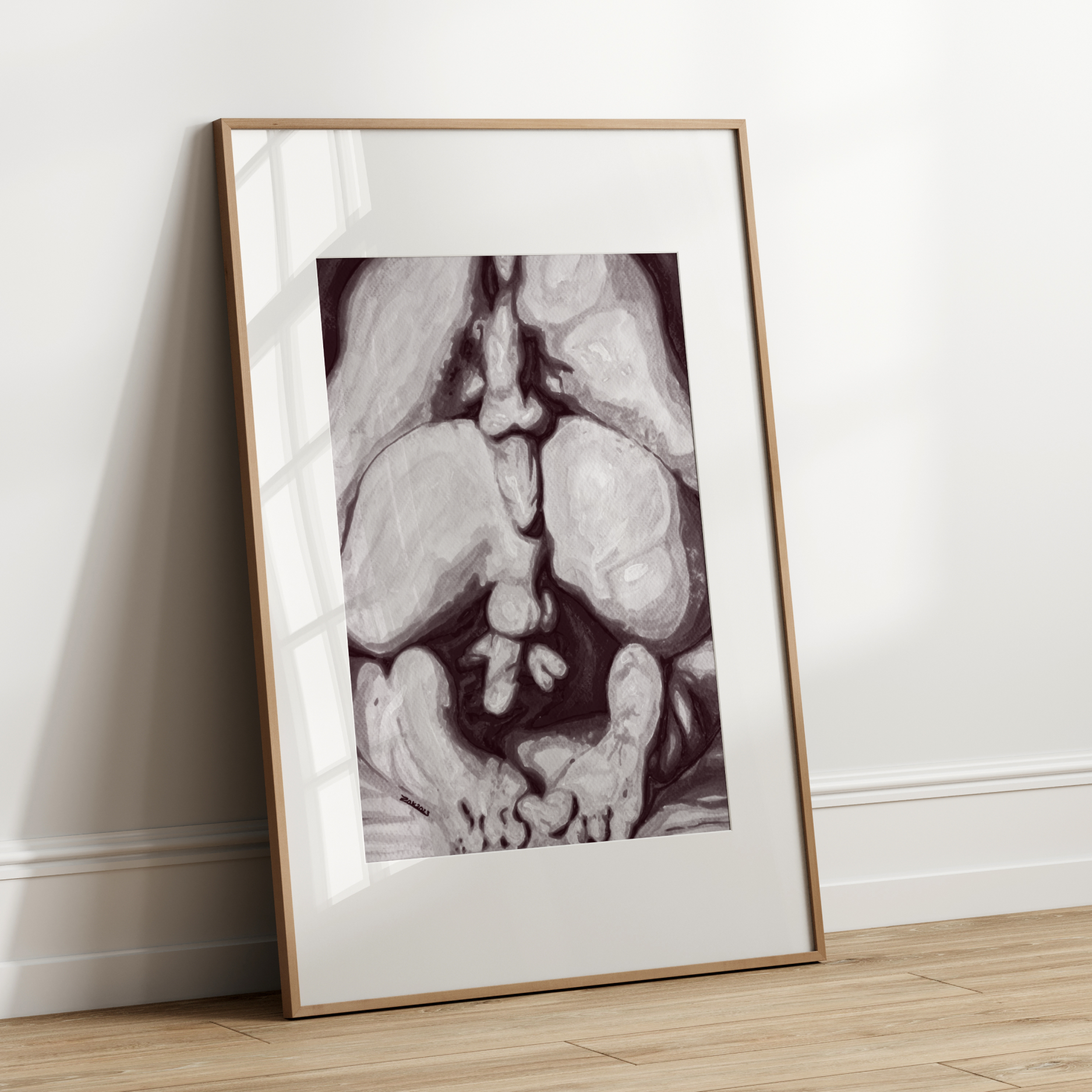Framed black and white artwork leaning against a white wall.