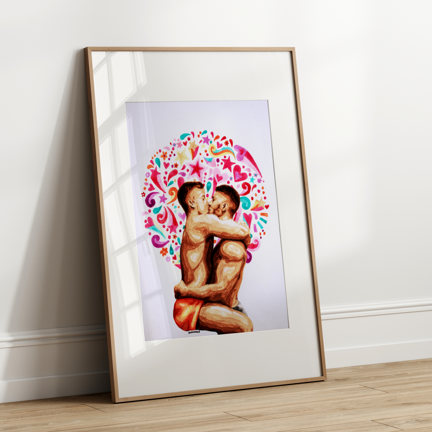 Framed artwork of two people embracing with a colorful floral design on a white wall.