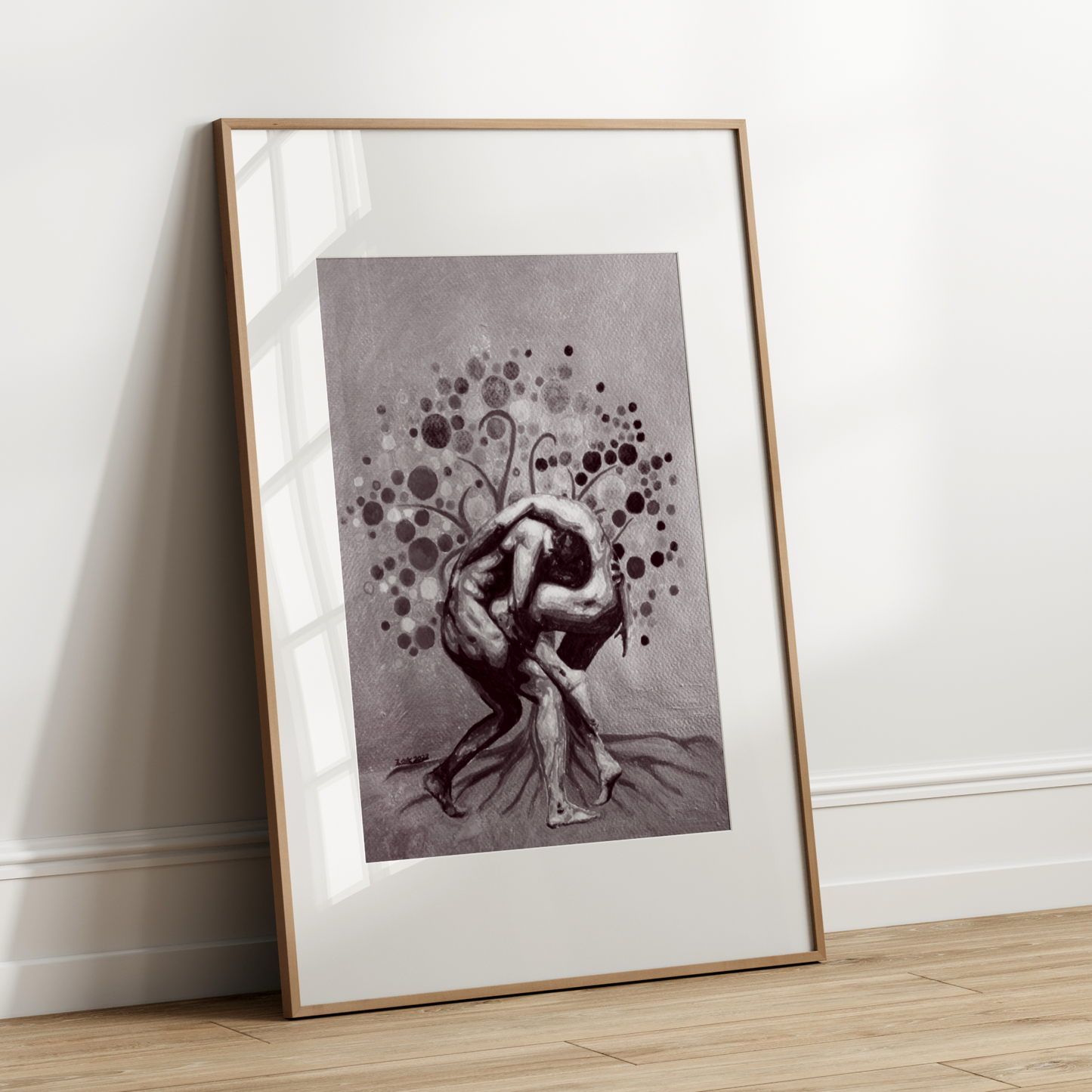 Framed black and white artwork of a nude figure leaning against a wall.