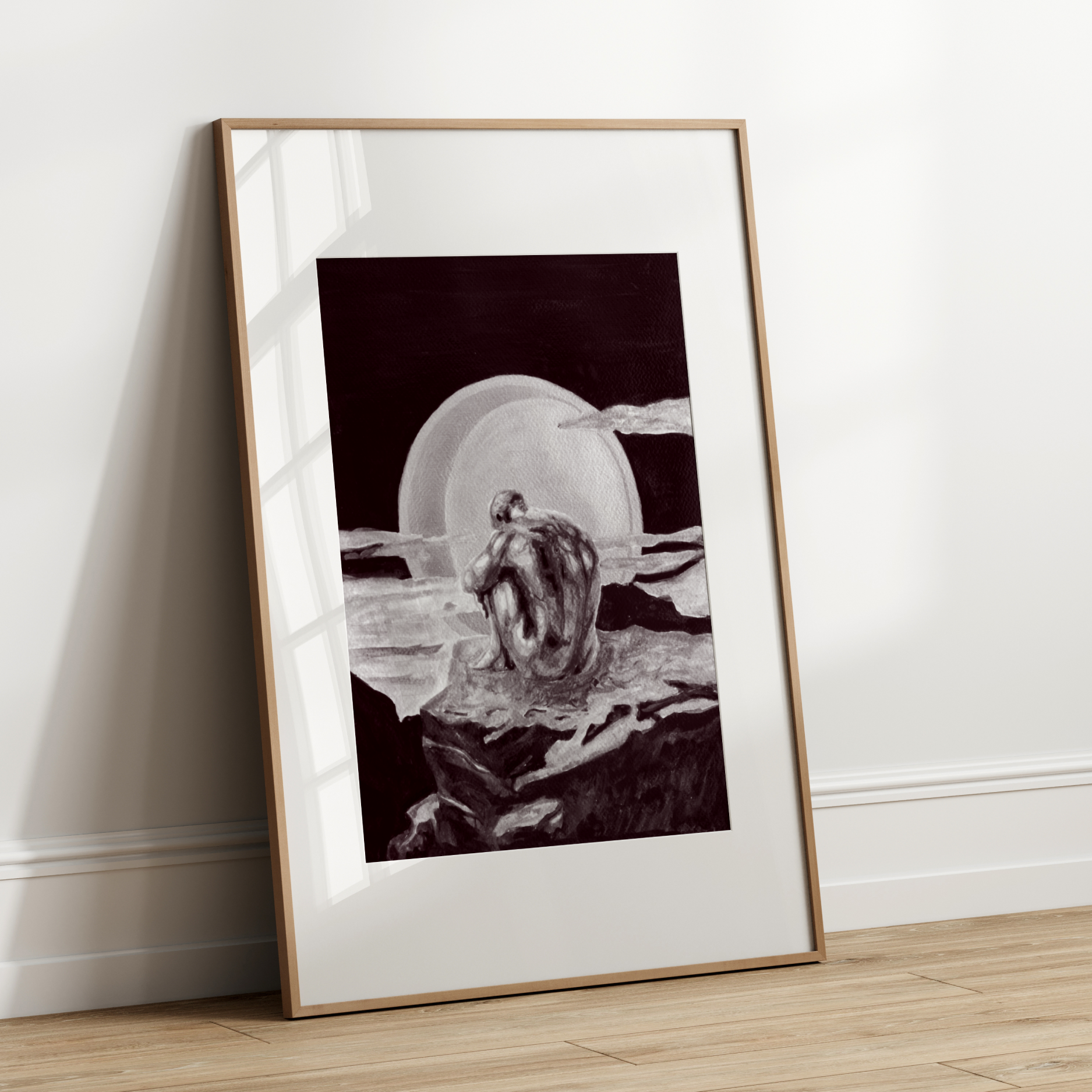 Framed black and white artwork leaning against a white wall.