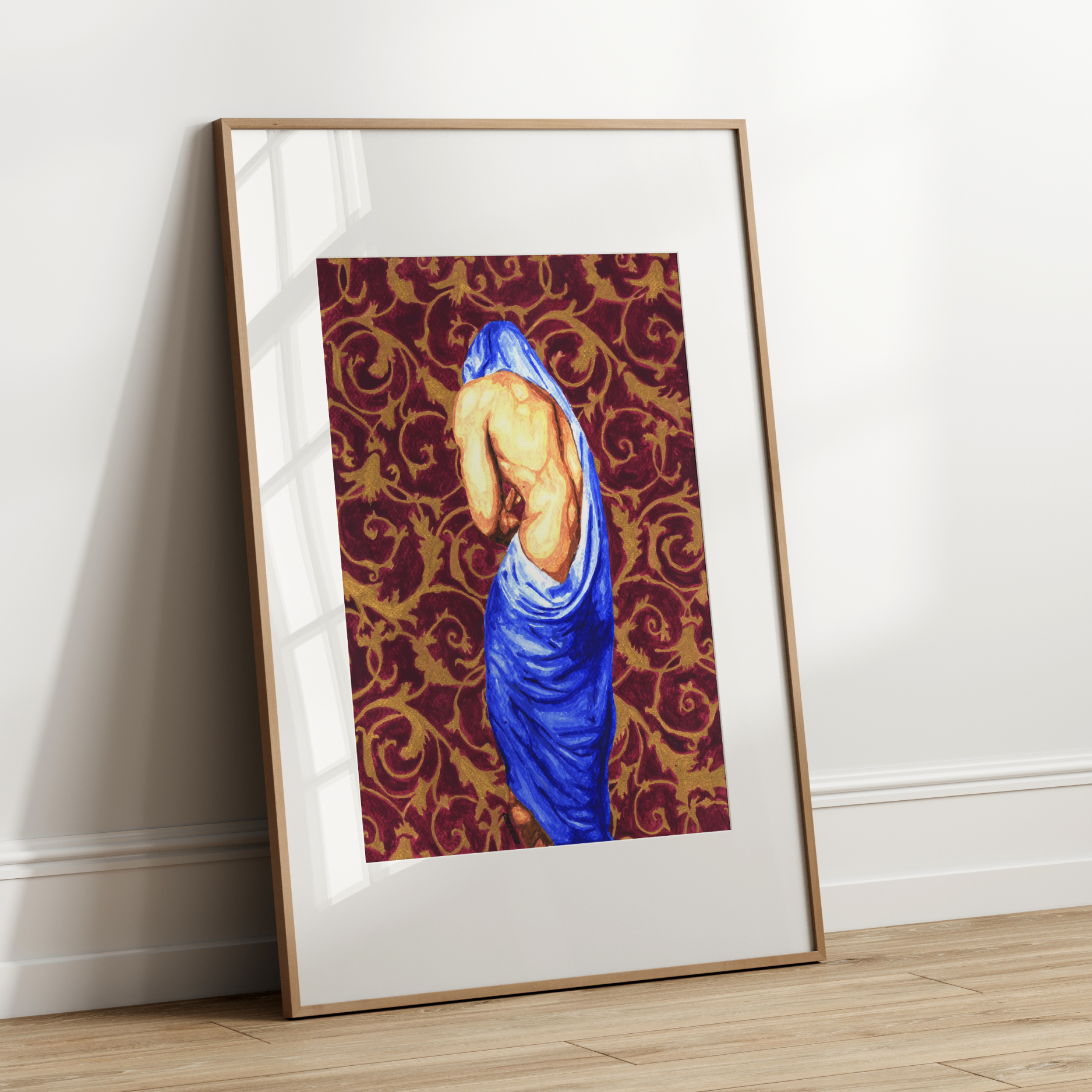 Framed artwork of a draped figure against a patterned background on a white wall.