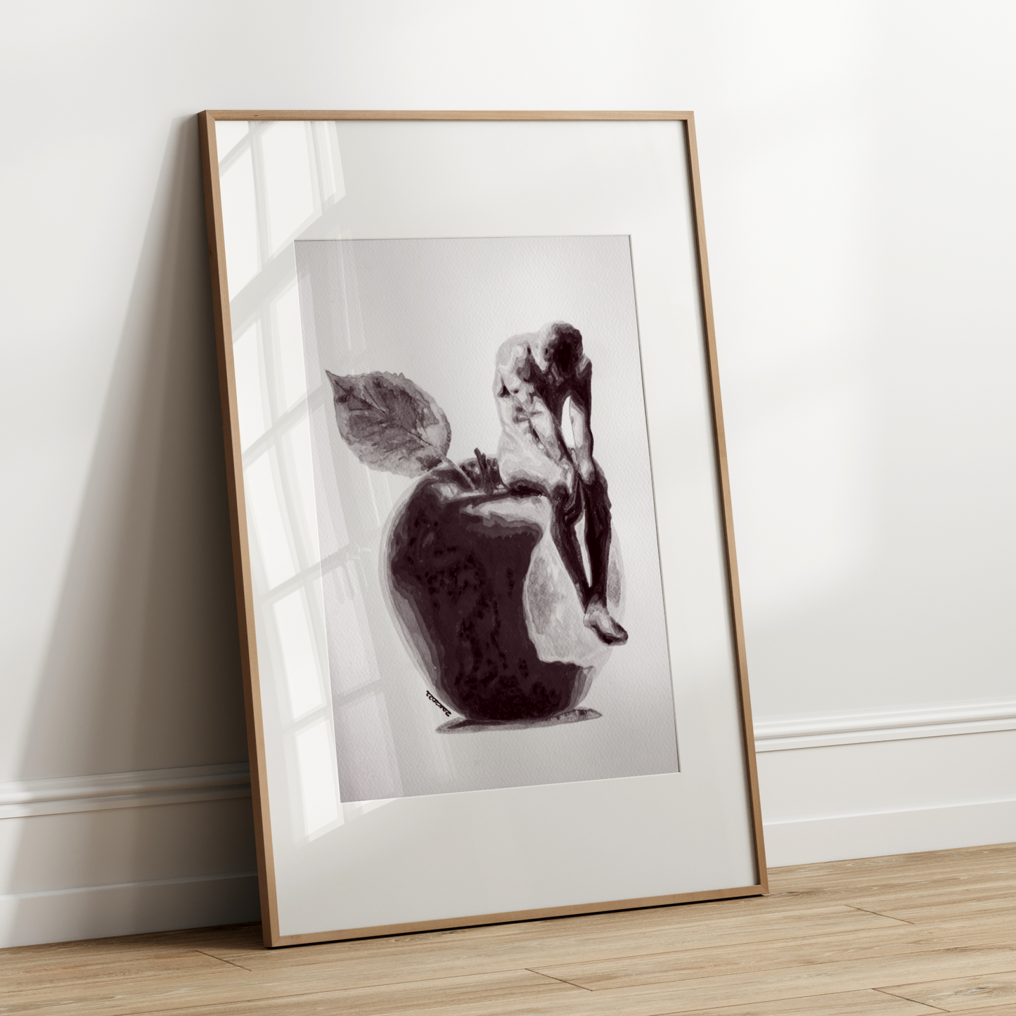 Framed black and white artwork leaning against a white wall.