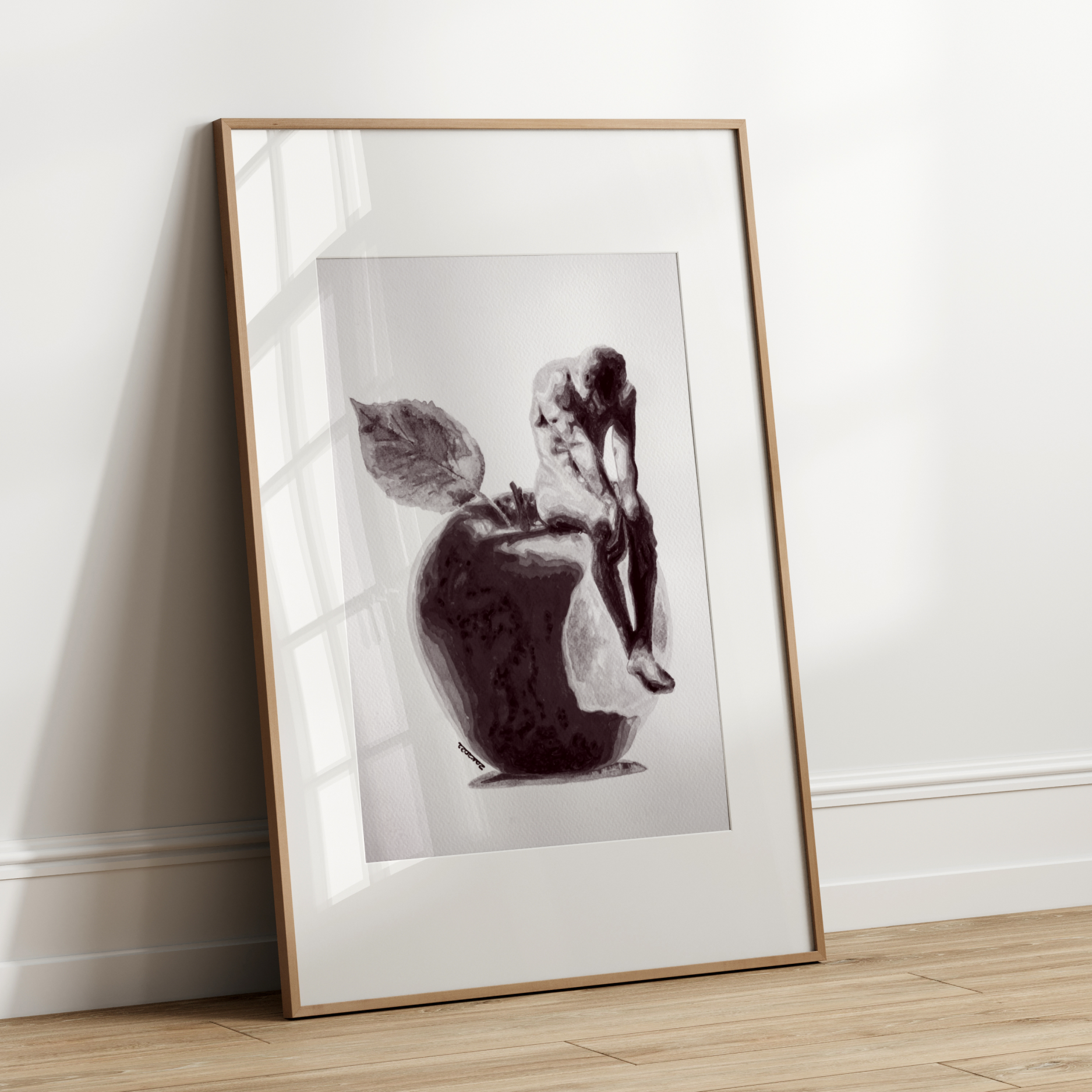 Framed black and white artwork leaning against a white wall.