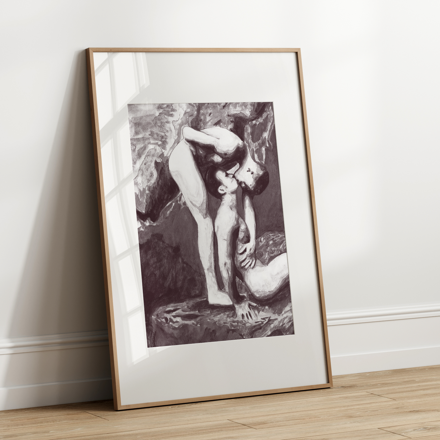 Framed black and white artwork leaning against a white wall.