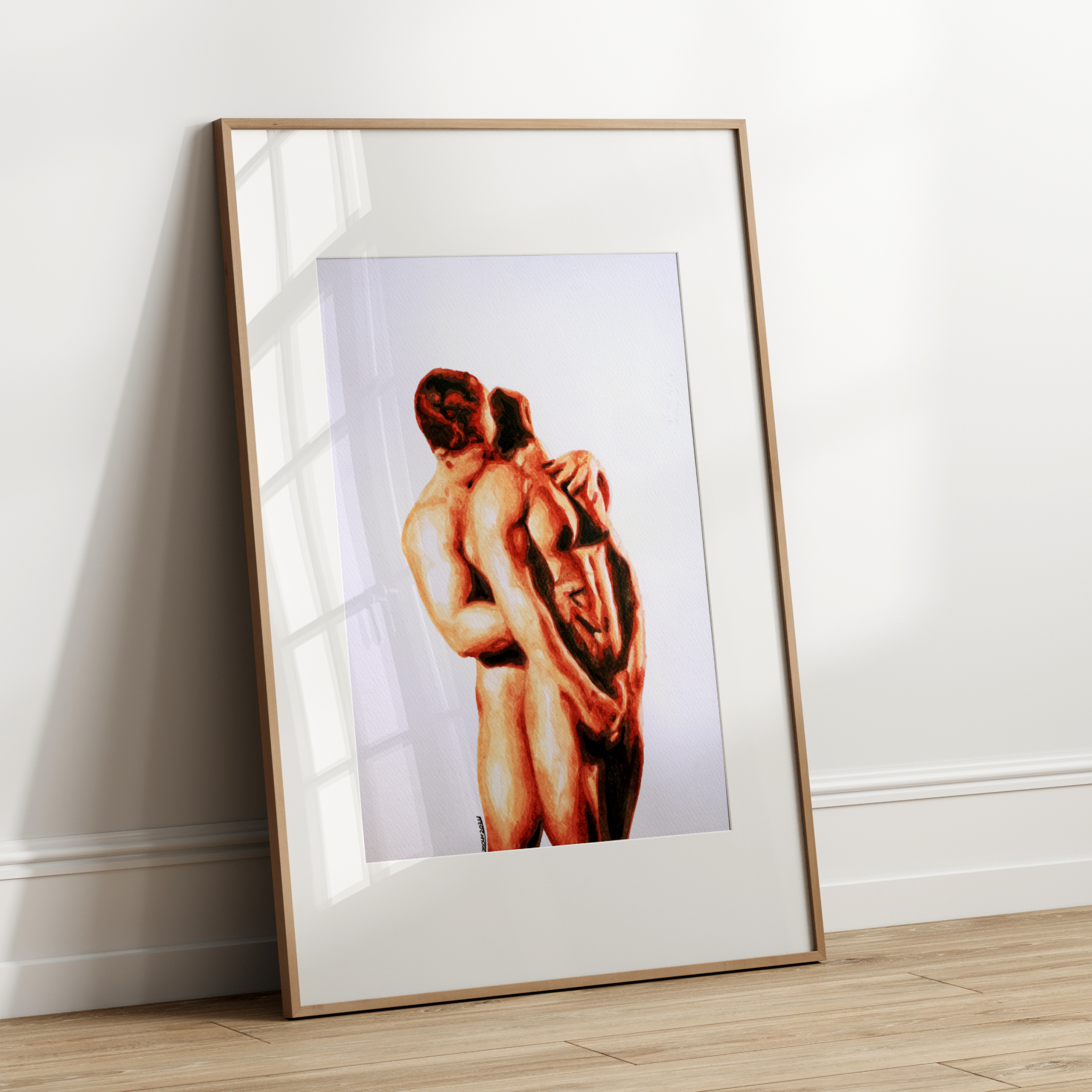 Framed artwork of two nude figures embracing on a white wall.