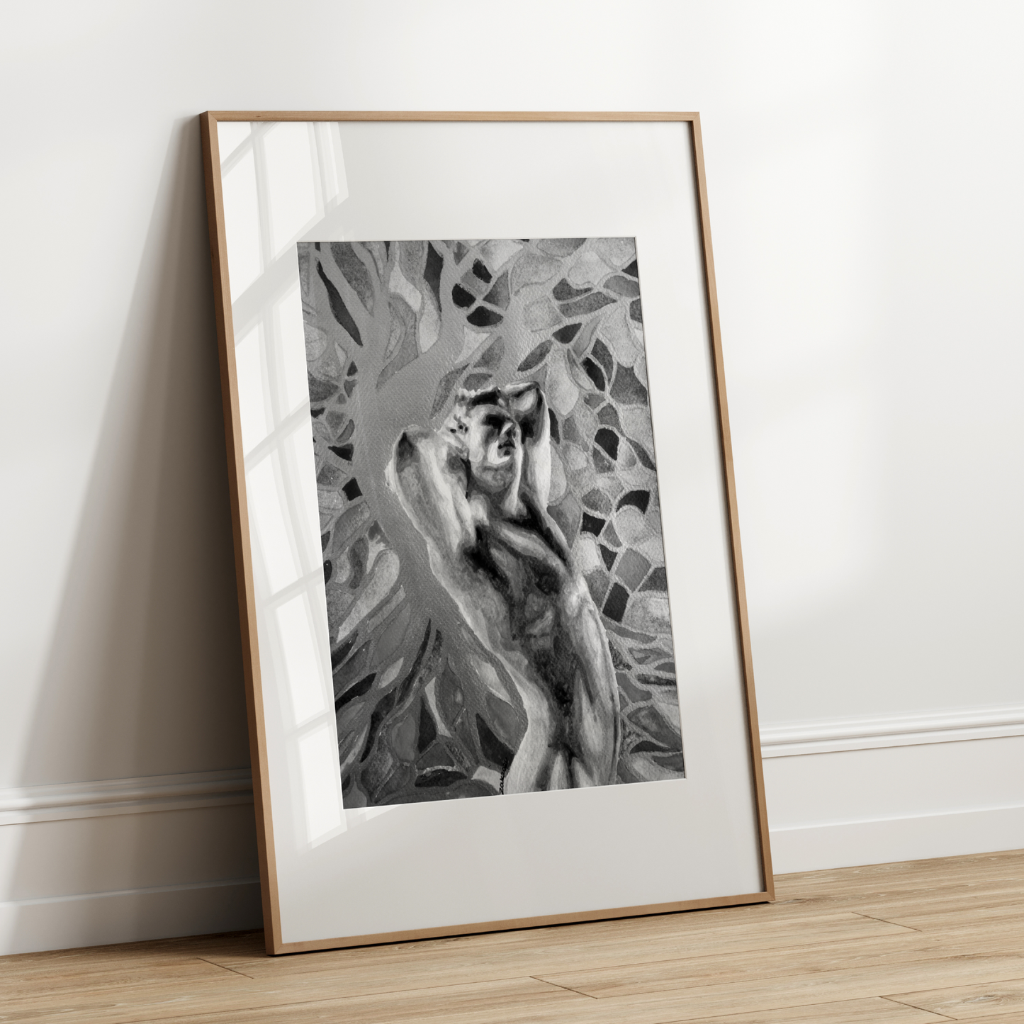 Framed black and white artwork of a deer in a natural setting on a white wall.