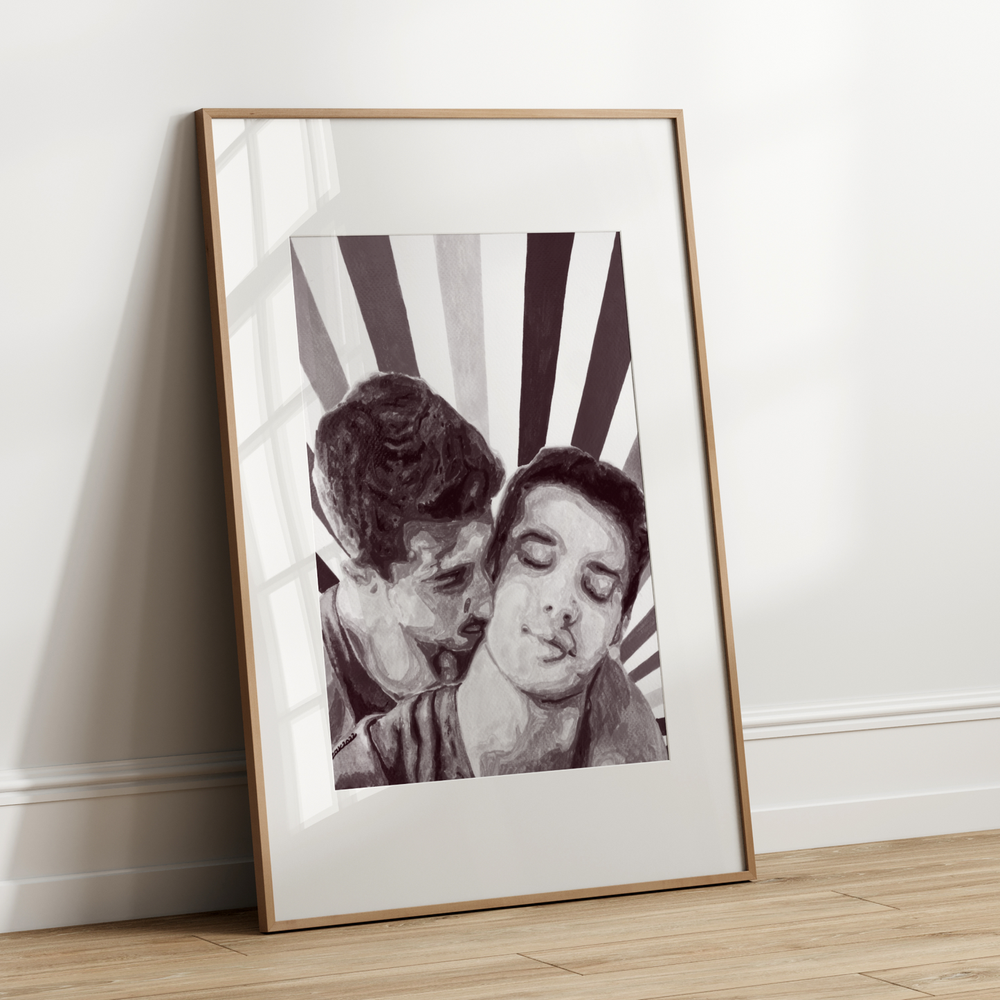 Framed black and white photograph of two people leaning in close against a striped background on a wooden floor.