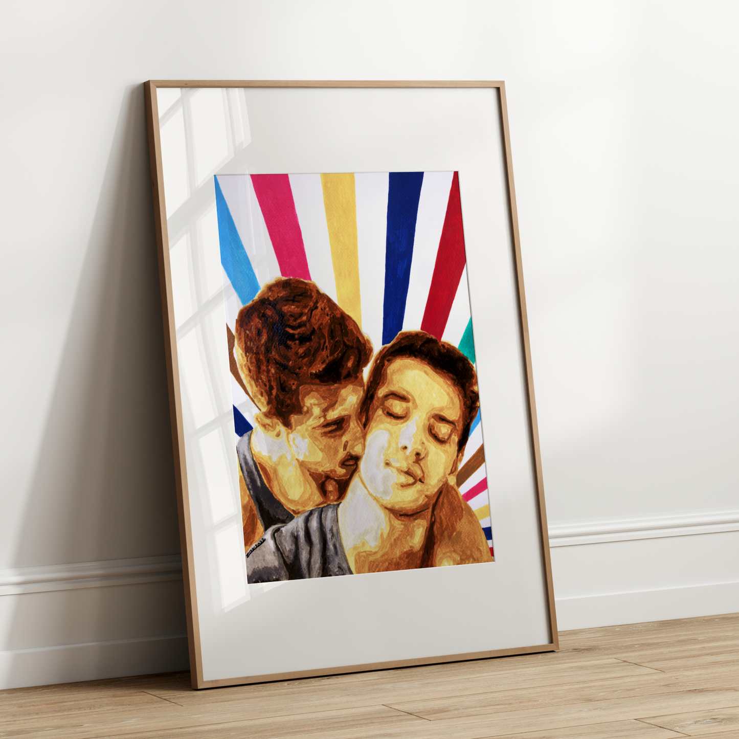 Framed artwork of two people kissing with a colorful striped background on a white wall.