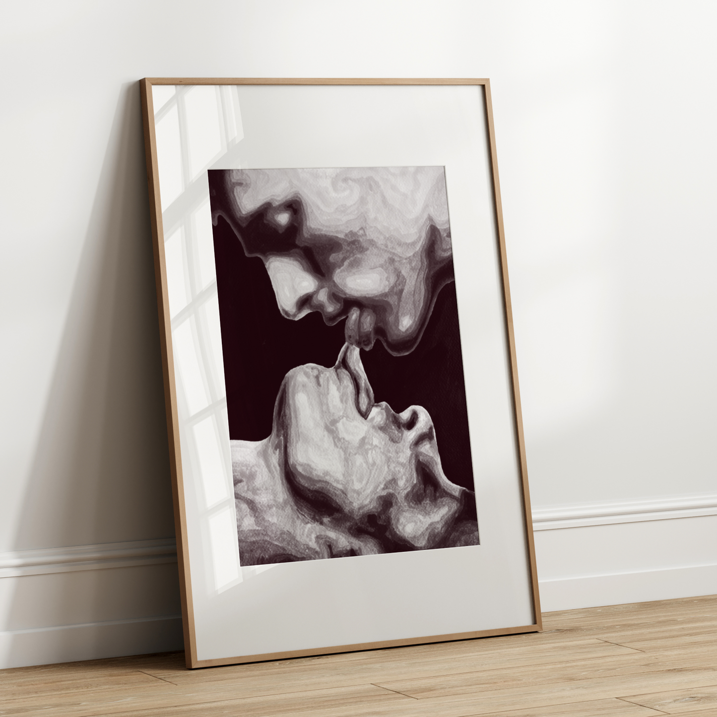 Framed artwork of a black and white portrait leaning against a white wall.