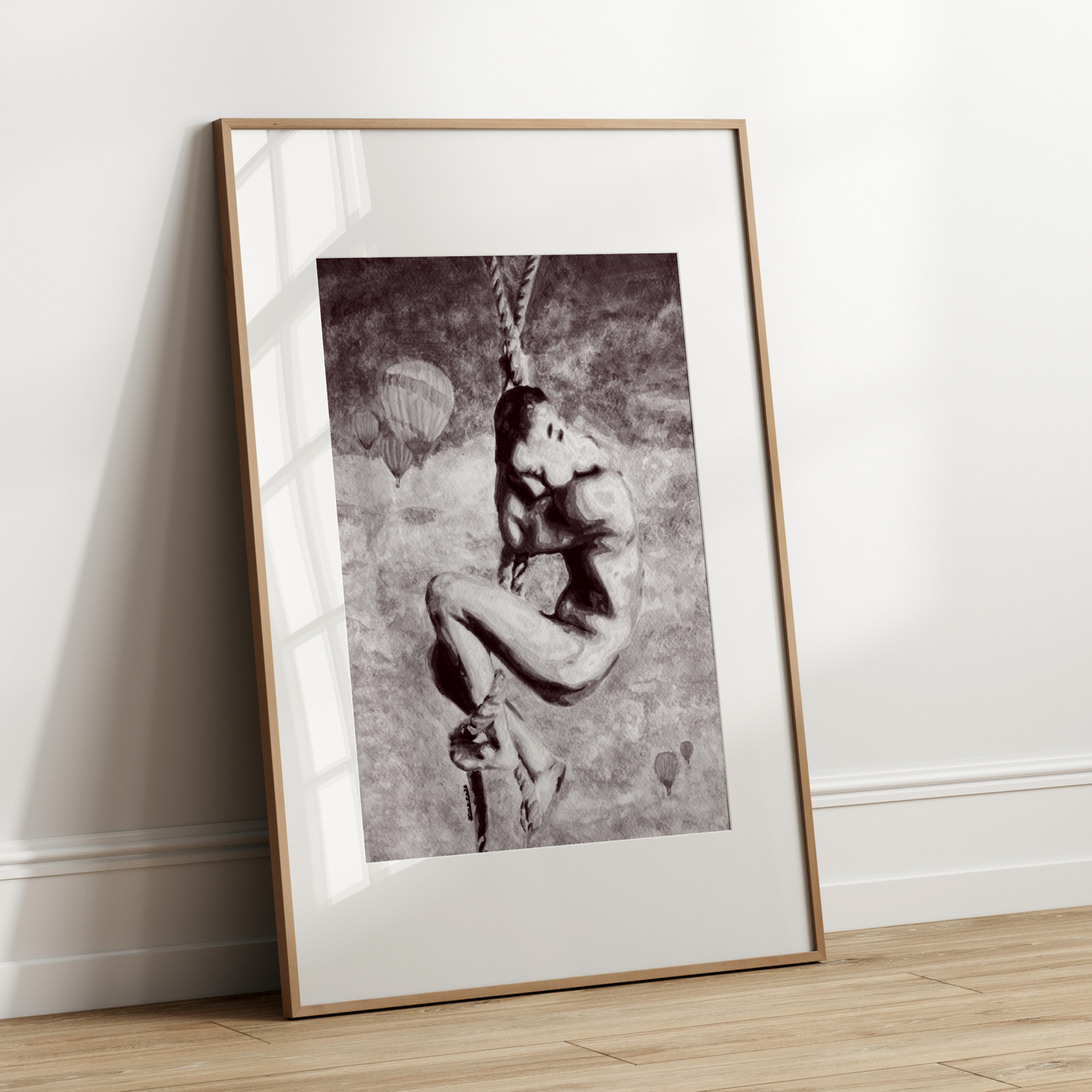 Framed black and white artwork leaning against a white wall.