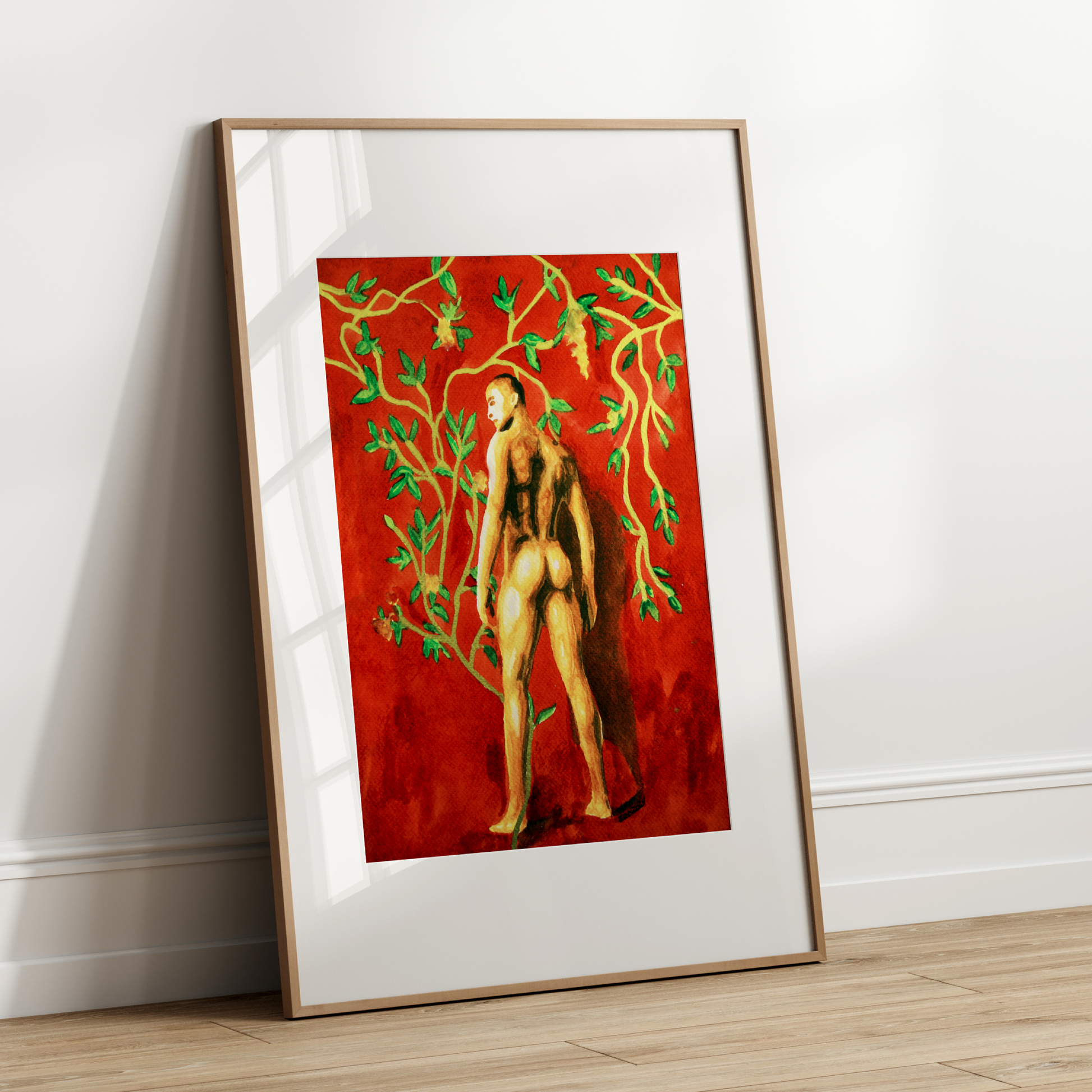 Framed artwork of a nude figure with green vines on a red background, leaning against a white wall.