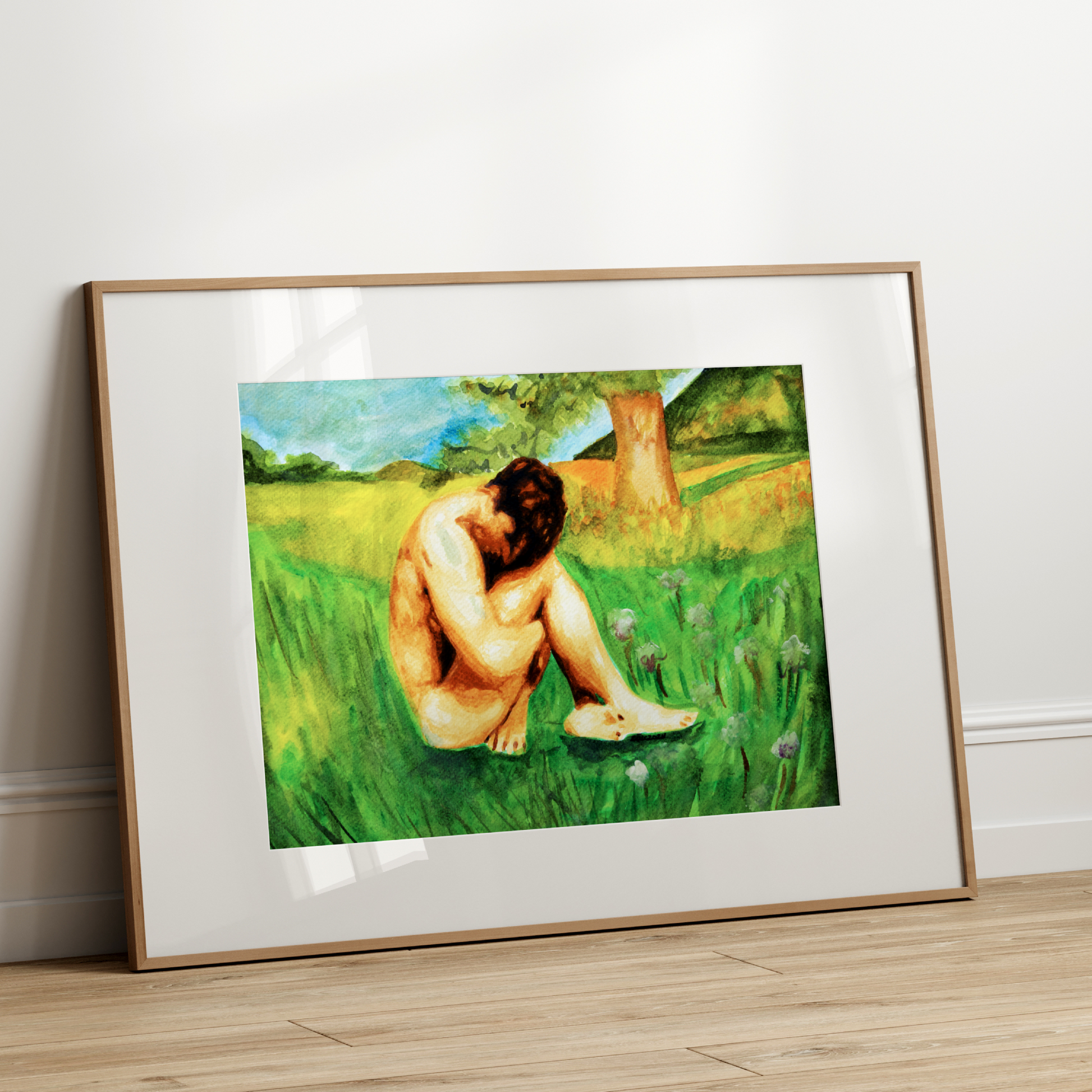 Framed artwork of a nude figure in a grassy field on a white wall.