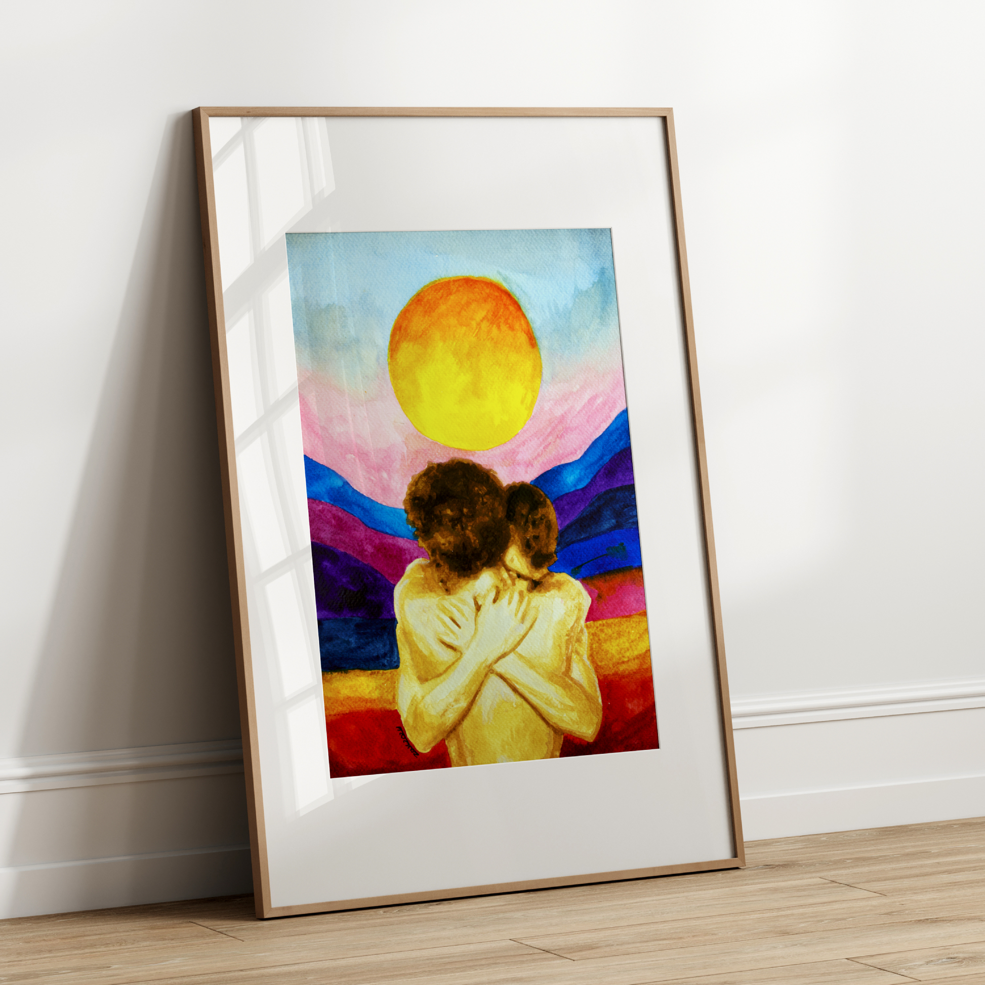 Framed artwork of two people embracing with a colorful background on a white wall.
