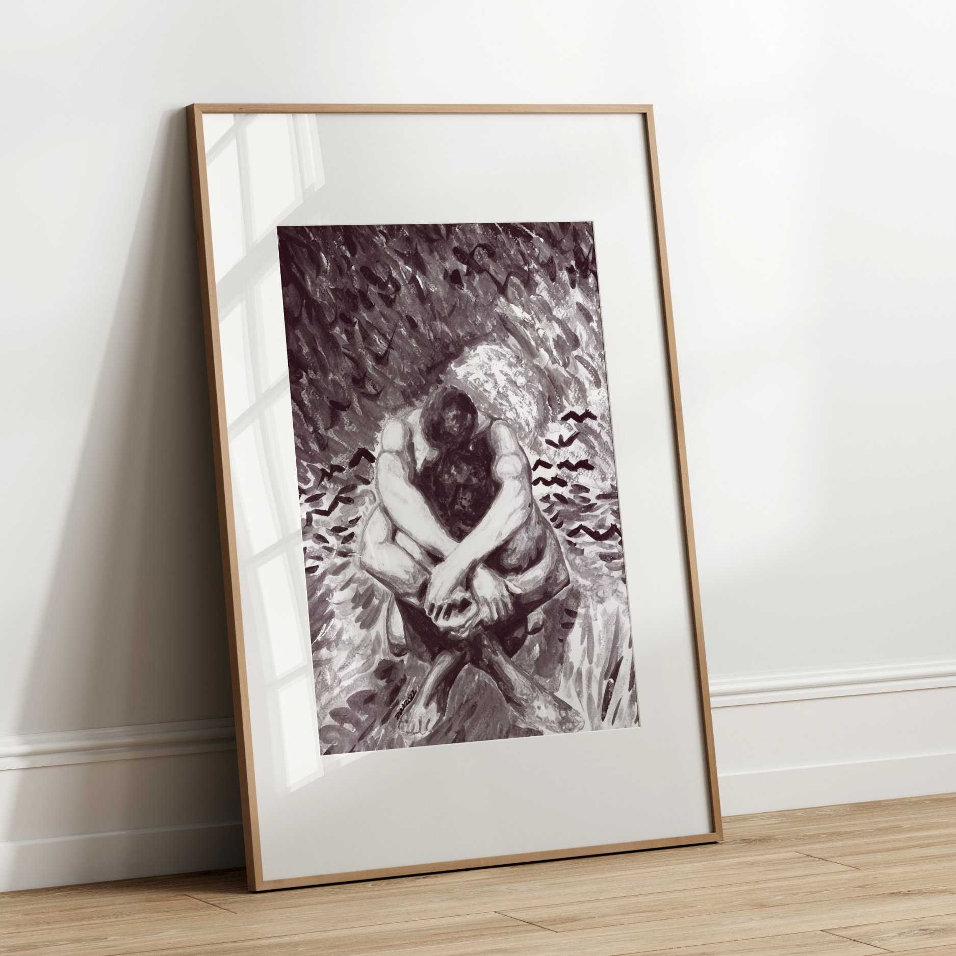 Framed black and white artwork leaning against a white wall.