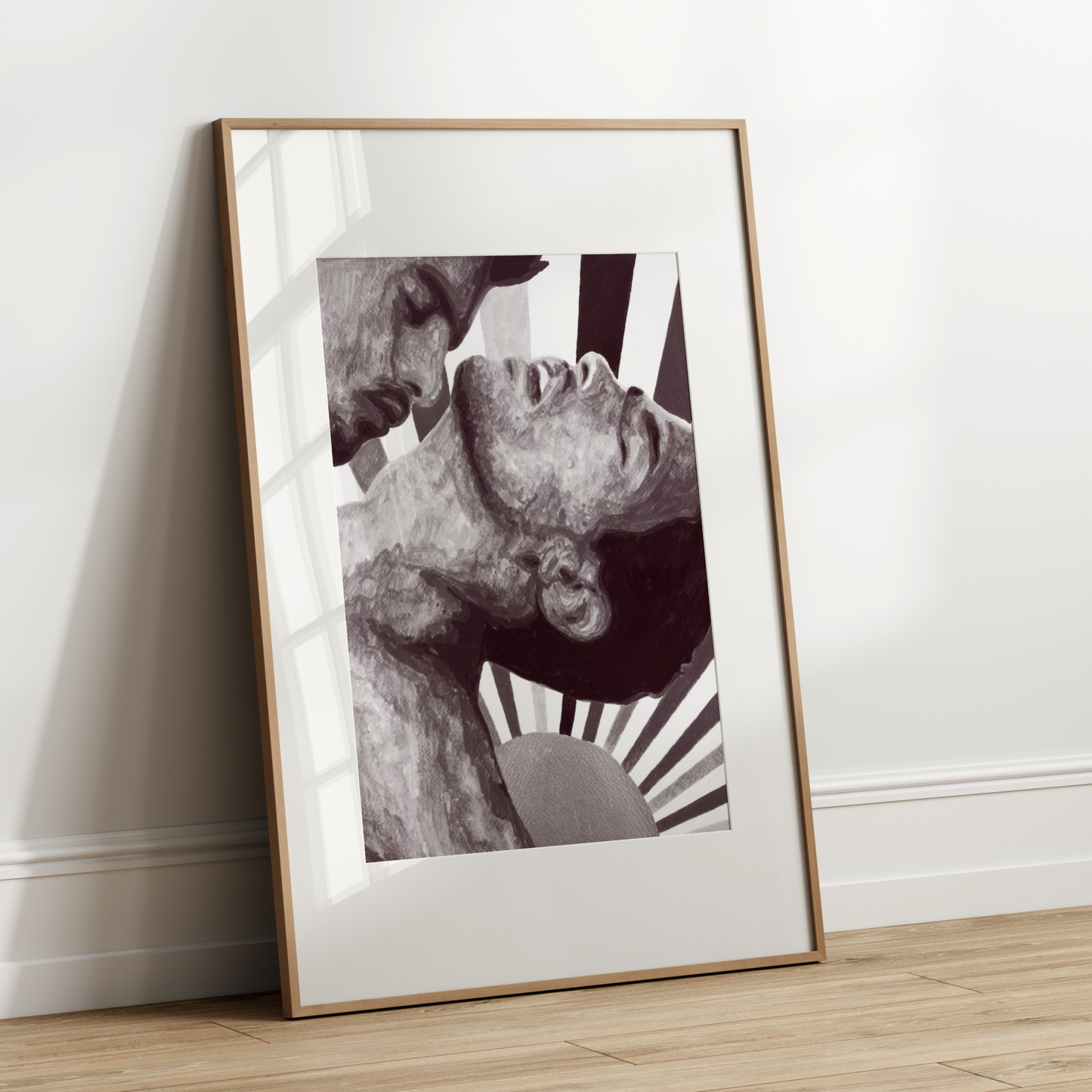 Framed black and white artwork leaning against a white wall.